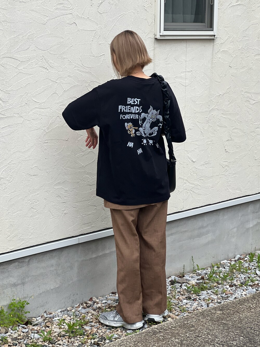 ブラック系のTシャツ/カットソー、ベージュ系のその他パンツ、シルバー系のスニーカーを着用したレディースの春コーディネートの2枚目の写真