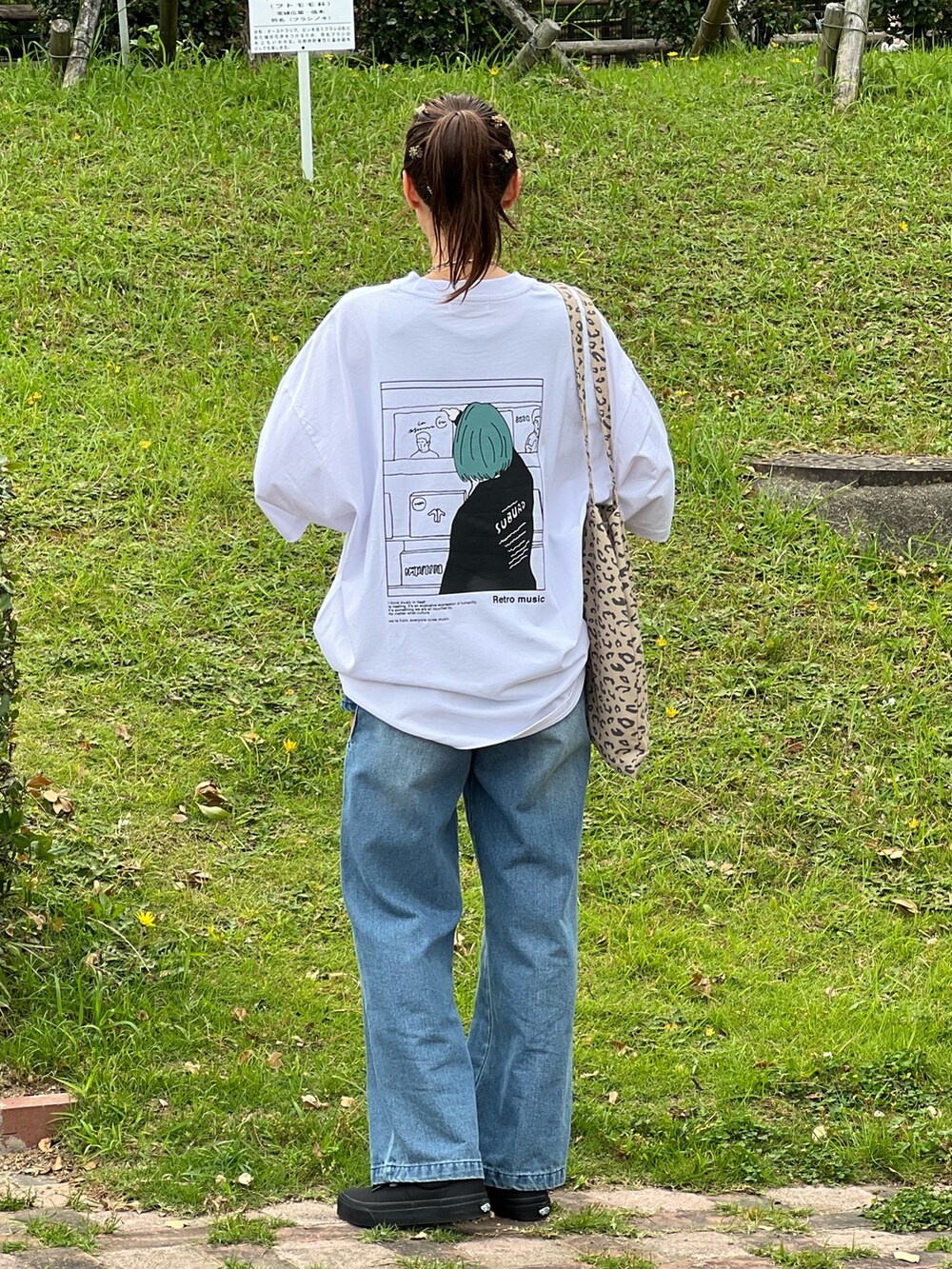 ホワイト系のTシャツ/カットソー、ブルー系のデニムパンツ、ブラック系のスニーカーを着用したレディースの夏コーディネートの2枚目の写真