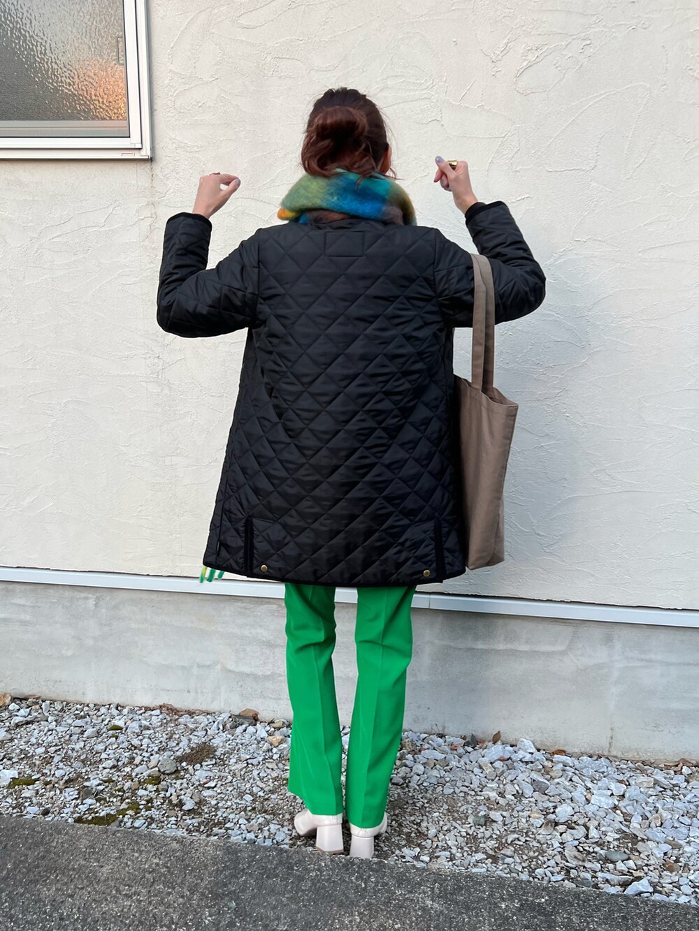 ブラック系のその他アウター、ブラウン系のトートバッグ、グリーン系のスラックスを着用したレディースの冬コーディネートの3枚目の写真