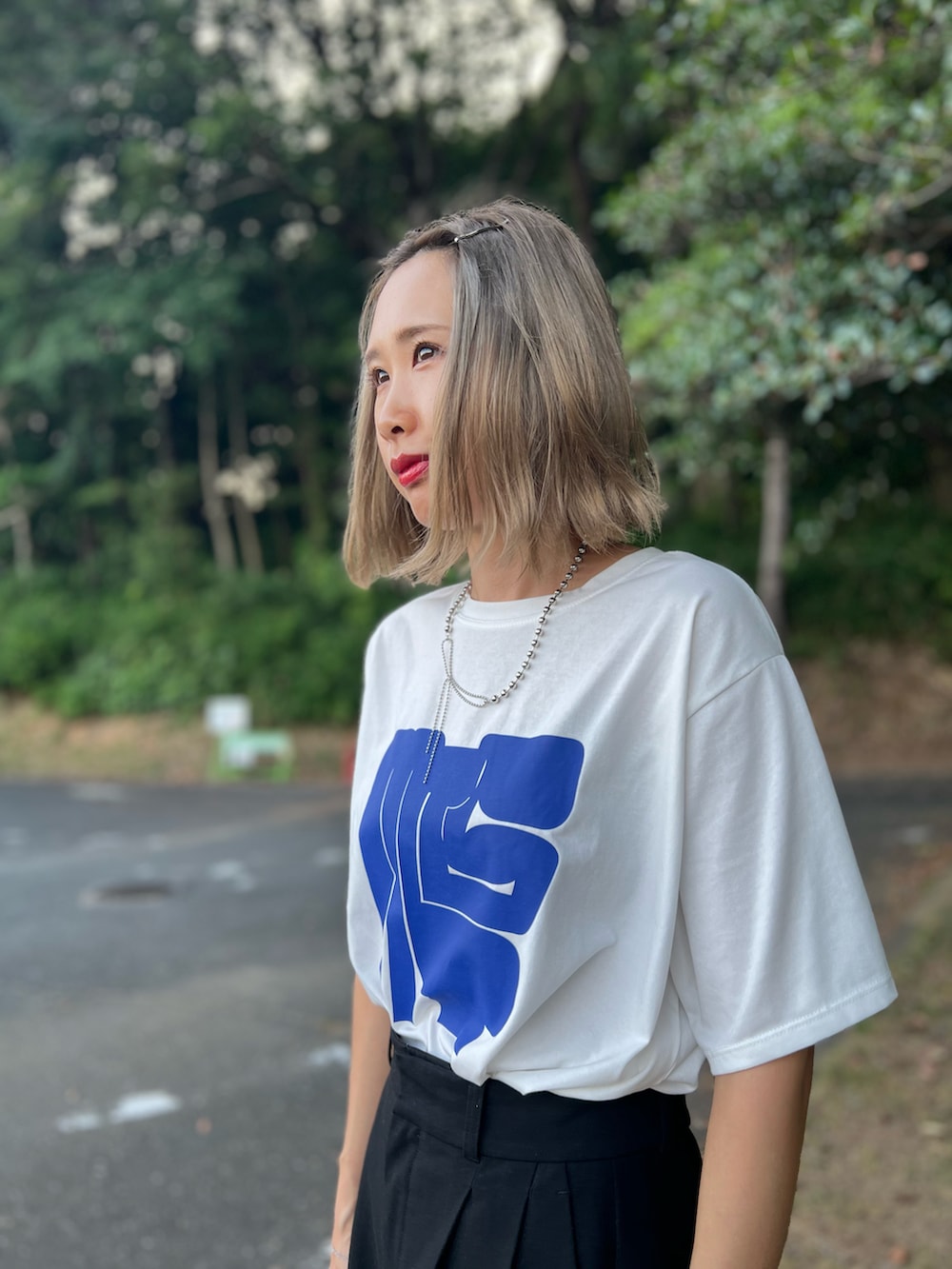 ホワイト系のTシャツ/カットソー、ベージュ系のトートバッグ、ブラック系のパンツを着用したレディースの秋コーディネートの2枚目の写真