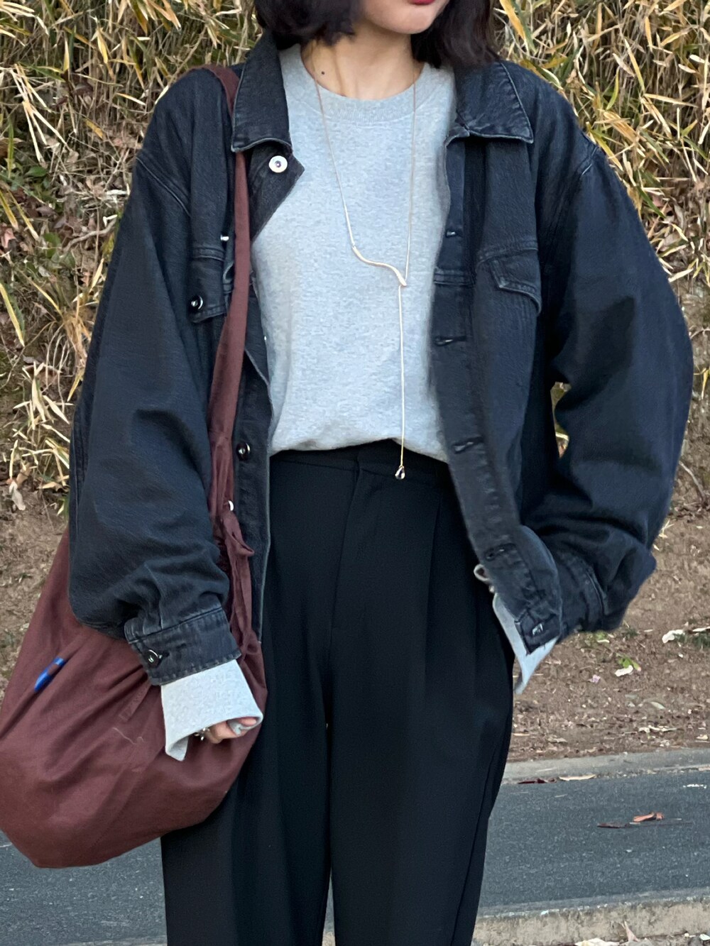 ブラック系のデニムジャケット、グレー系のスウェット、ブラック系のパンツを着用したレディースの冬コーディネートの4枚目の写真