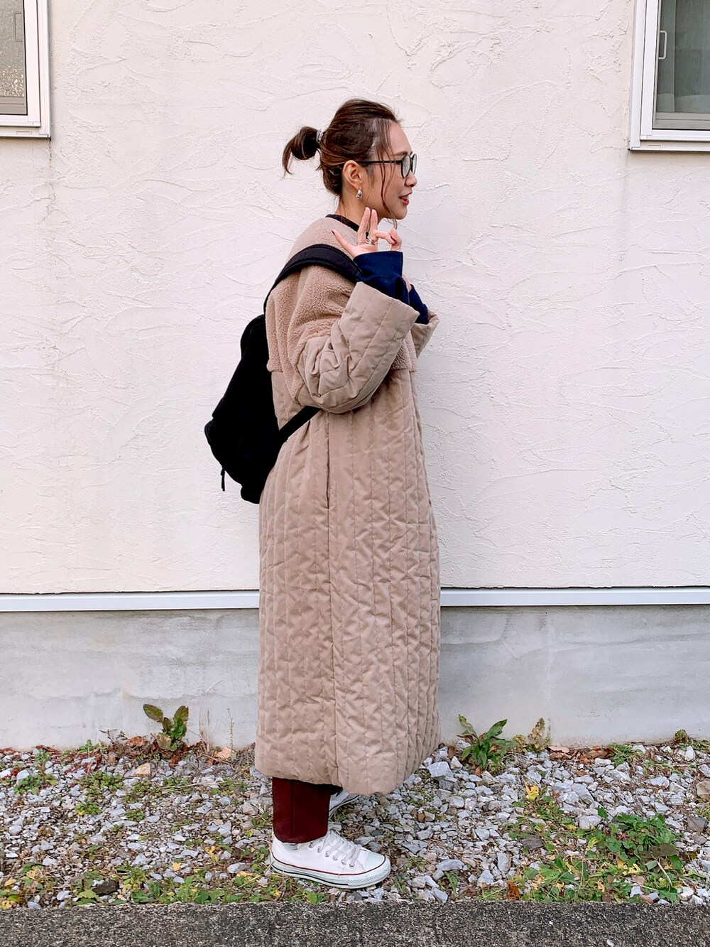 ベージュ系のノーカラーコート、ブラウン系のその他パンツ、ホワイト系のスニーカーを着用したレディースの冬コーディネートの2枚目の写真