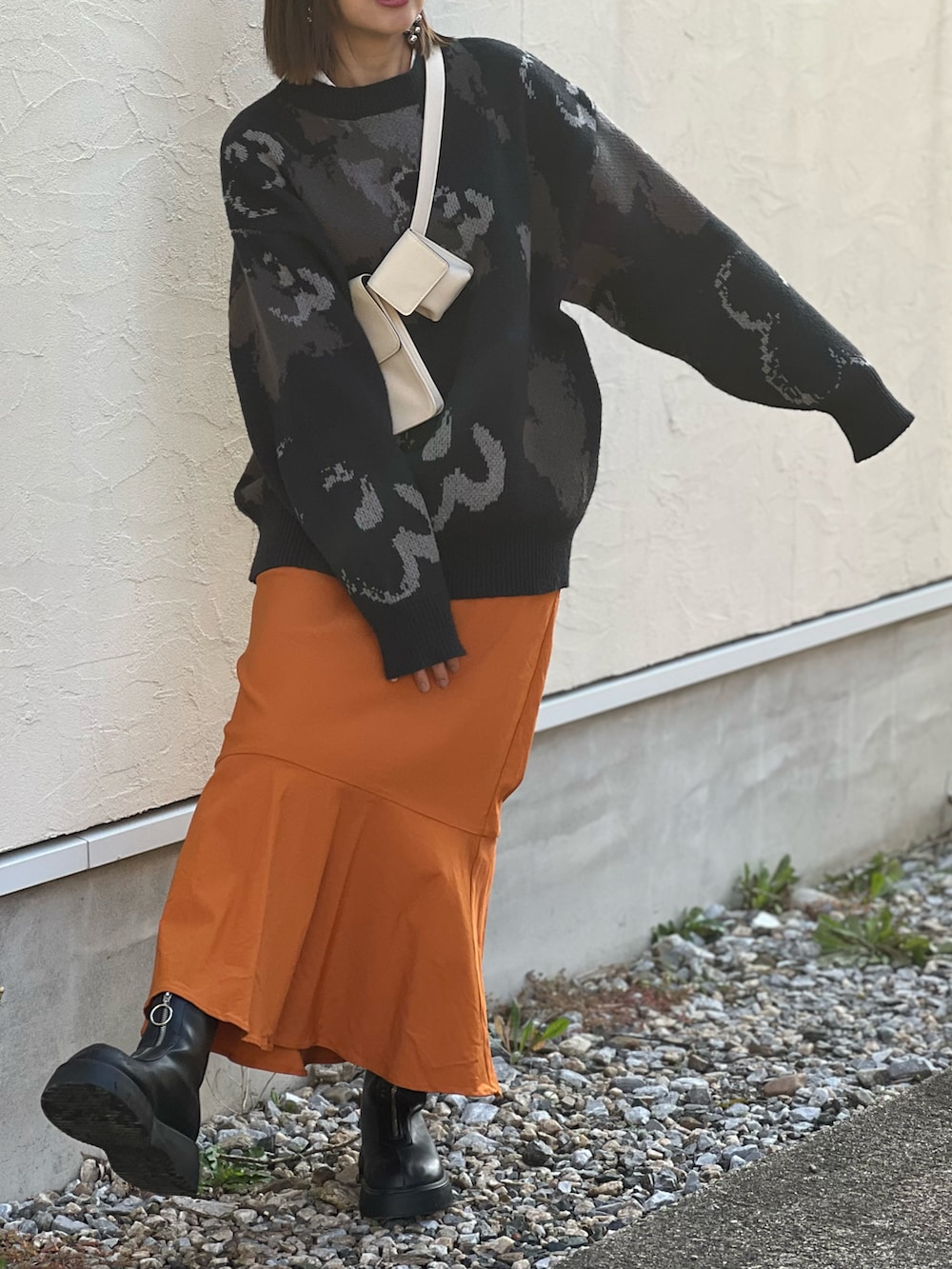 ブラック系のニット/セーター、イエロー系のスカート、ブラック系のブーツを着用したレディースの秋コーディネートの3枚目の写真