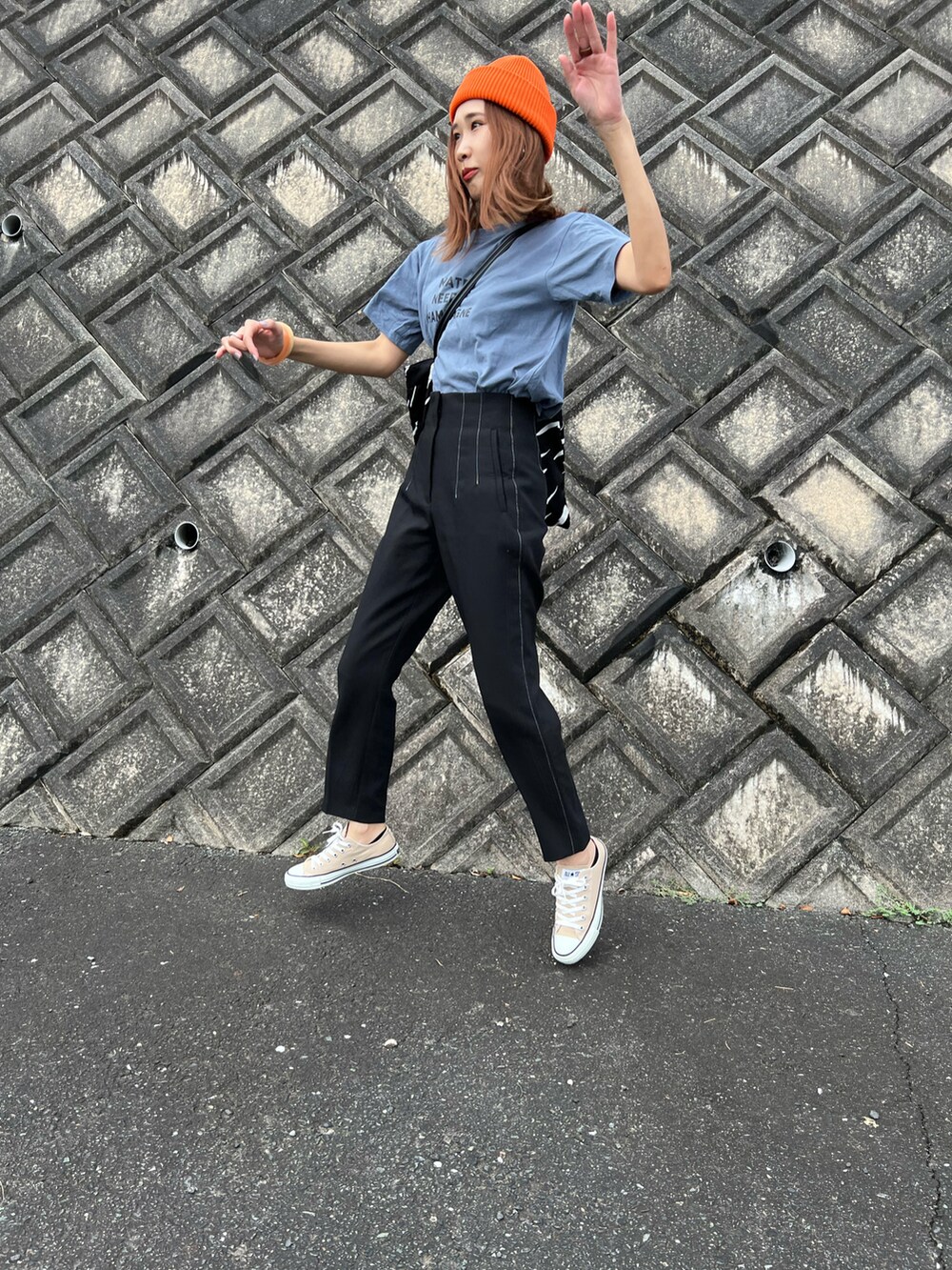 ブルー系のTシャツ/カットソー、ブラック系のパンツ、ベージュ系のスニーカーを着用したレディースの秋コーディネートの4枚目の写真