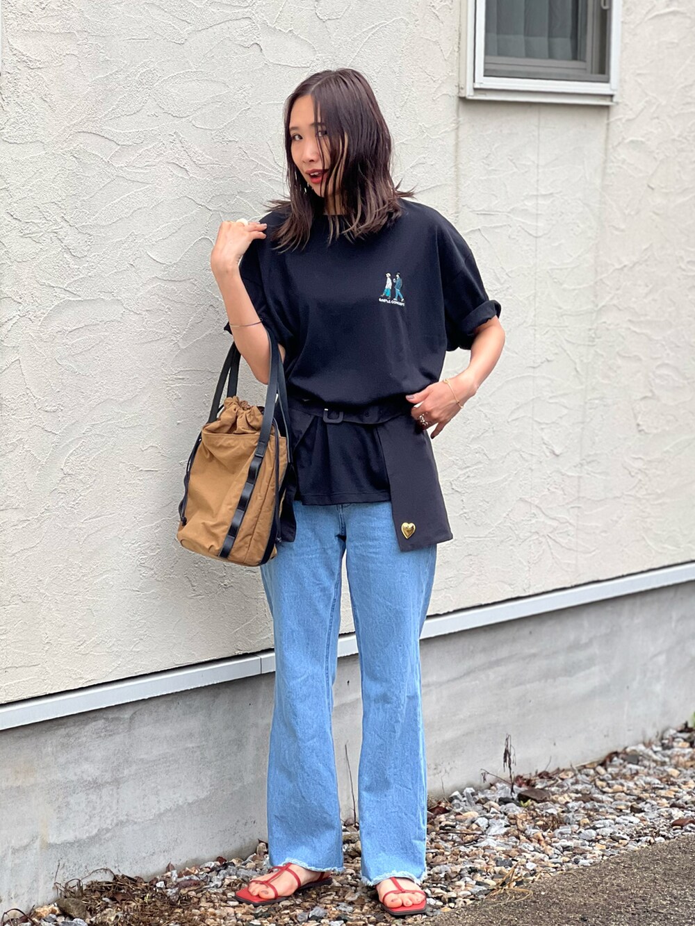 ブラック系のTシャツ/カットソー、ブルー系のデニムパンツ、ベージュ系のトートバッグを着用したレディースの春コーディネートの5枚目の写真