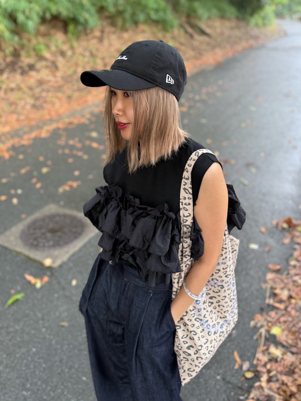 ブラック系のTシャツ/カットソー、ベージュ系のトートバッグ、シルバー系のスニーカーを着用したレディースの秋コーディネートの2枚目の写真
