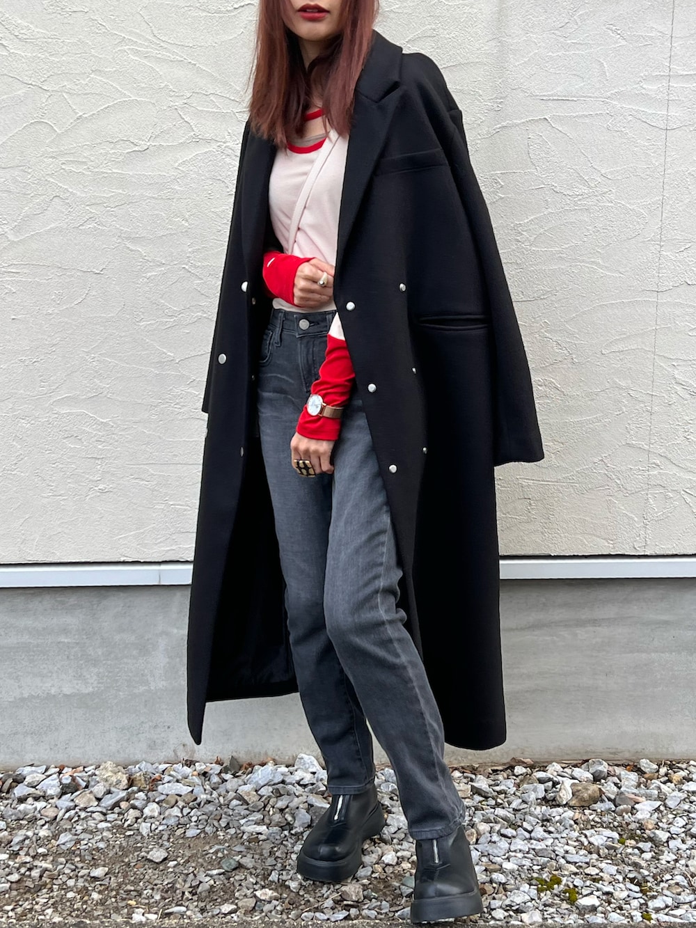 グレー系のデニムパンツ、レッド系のTシャツ/カットソー、ブラック系のチェスターコートを着用したレディースの冬コーディネートの5枚目の写真