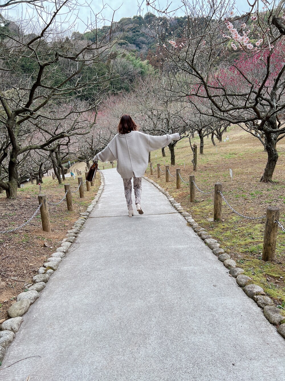 グレー系のニット/セーター、ホワイト系のブーツ、ブラウン系のトートバッグを着用したレディースの春コーディネートの5枚目の写真