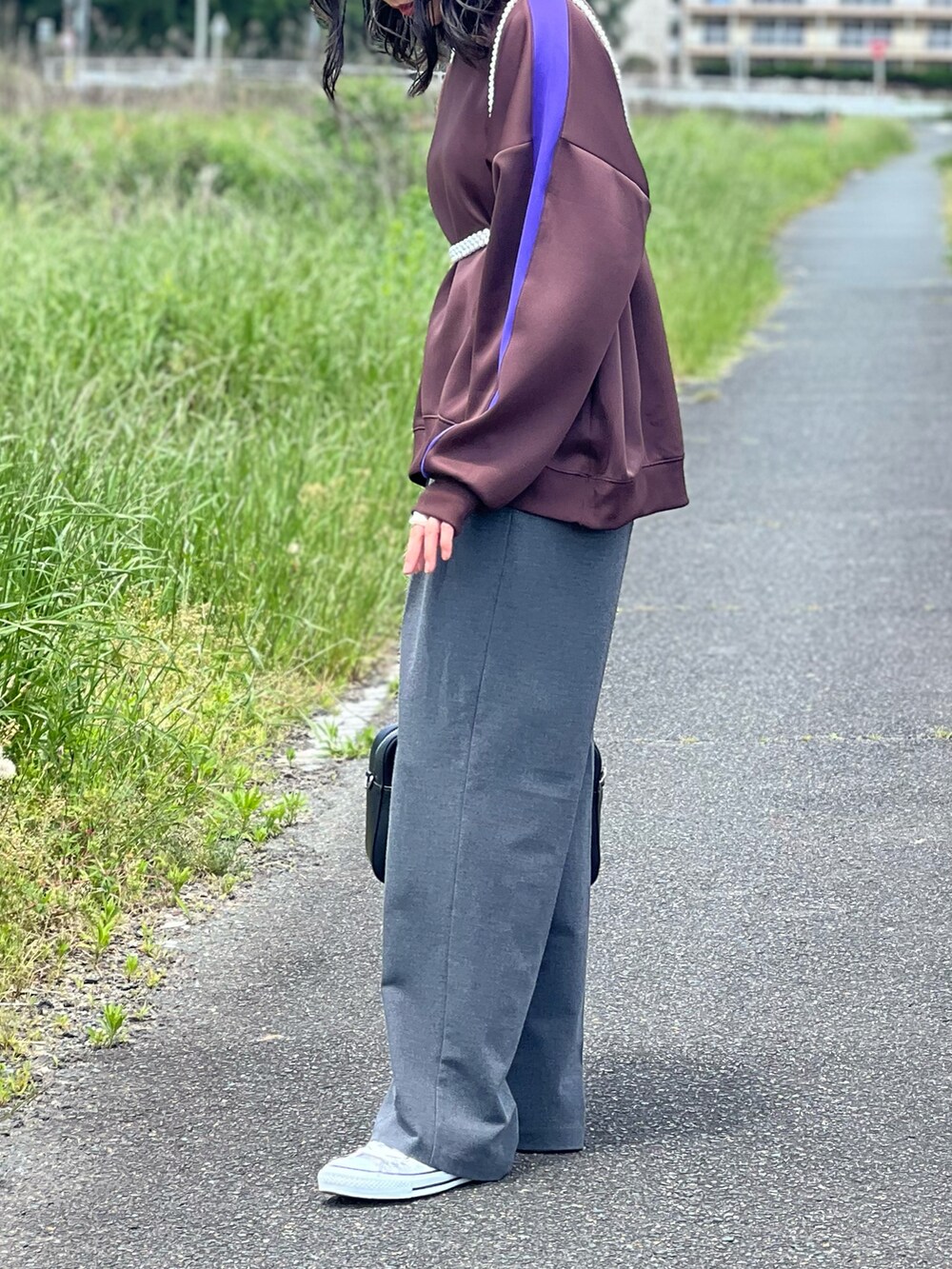 ブラウン系のその他トップス、グレー系のパンツ、シルバー系のスニーカーを着用したレディースの春コーディネートの3枚目の写真