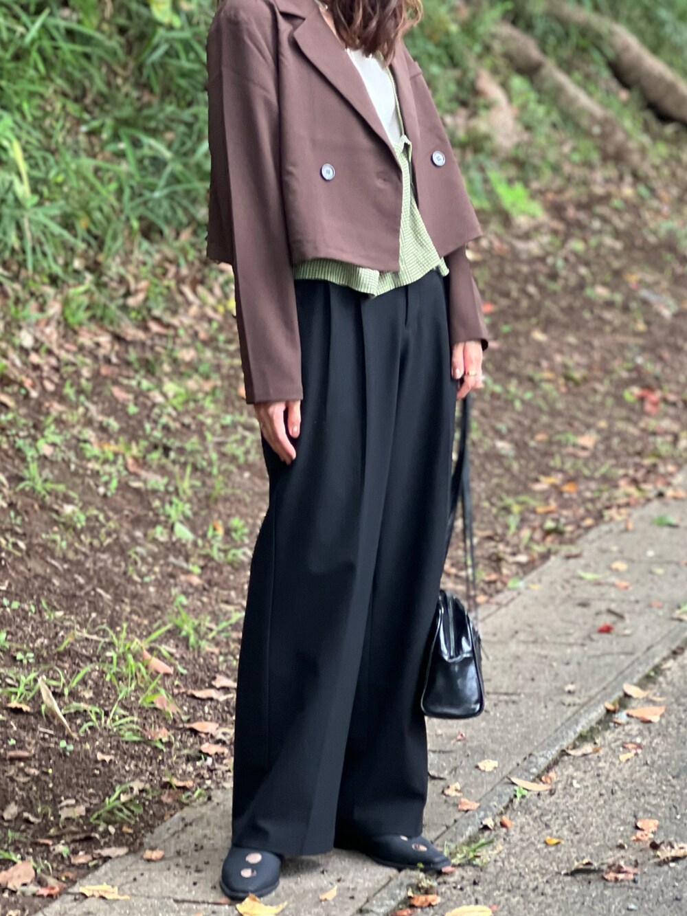 グリーン系のベスト、ブラウン系のジャケット/アウター、ブラック系のパンツを着用したレディースの秋コーディネートの3枚目の写真