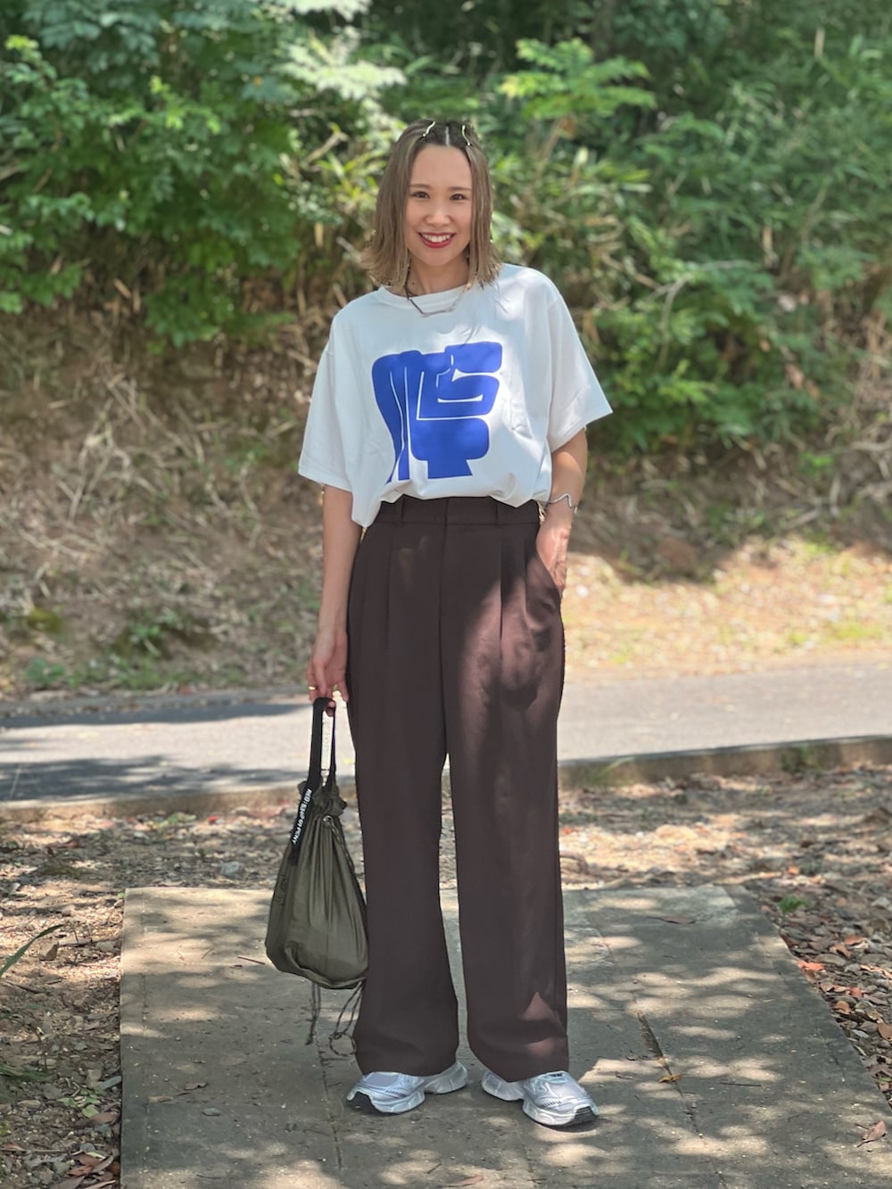 シルバー系のスニーカー、ホワイト系のTシャツ/カットソー、ブラウン系のパンツを着用したレディースの夏コーディネートの4枚目の写真