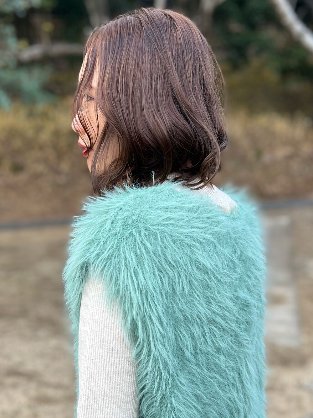 グリーン系のニット/セーター、ベージュ系のニット/セーター、ブラック系のボストンバッグを着用したレディースの冬コーディネートの4枚目の写真