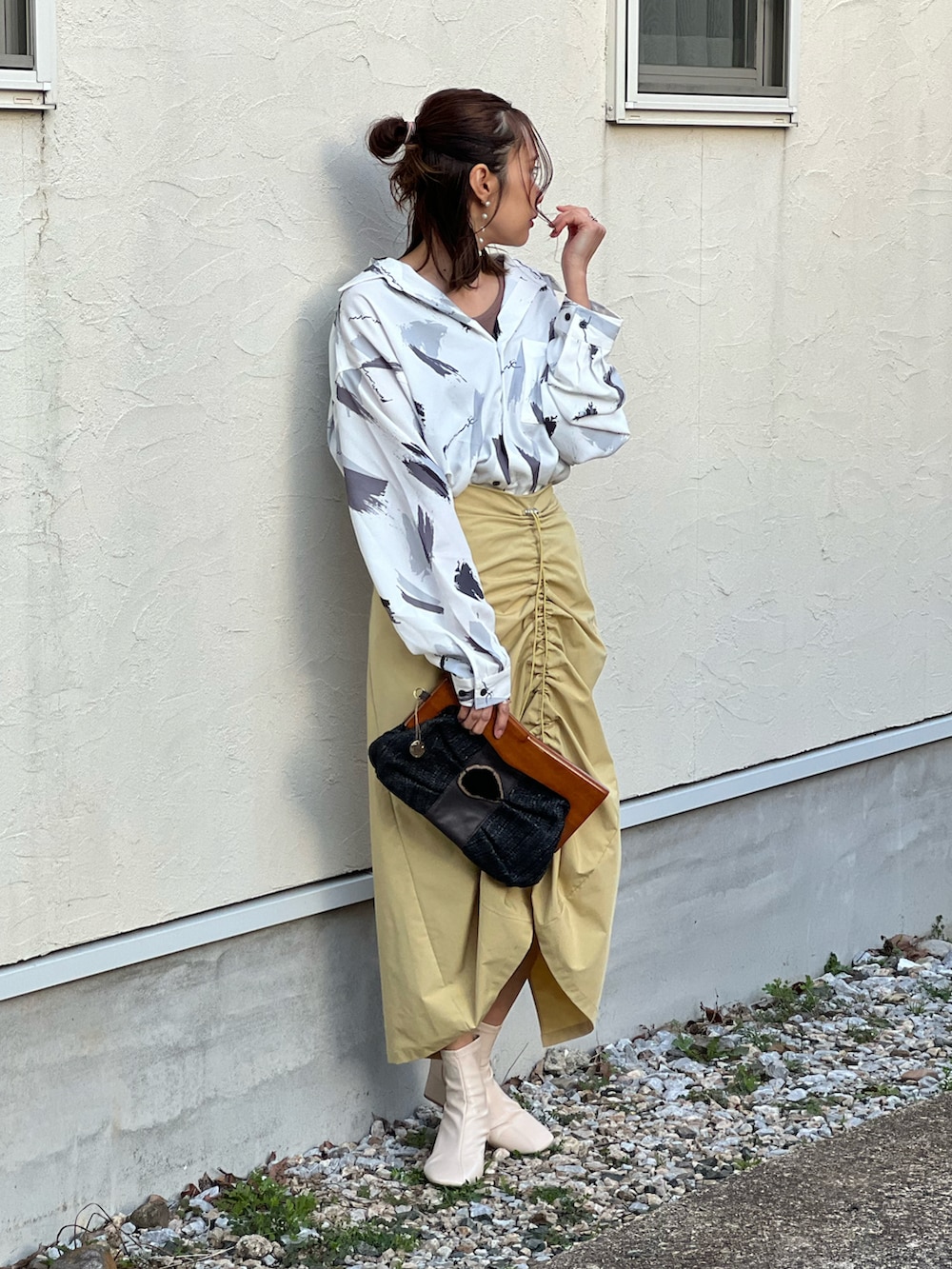 ホワイト系のシャツ/ブラウス、イエロー系のスカート、ホワイト系のブーツを着用したレディースの冬コーディネートの4枚目の写真