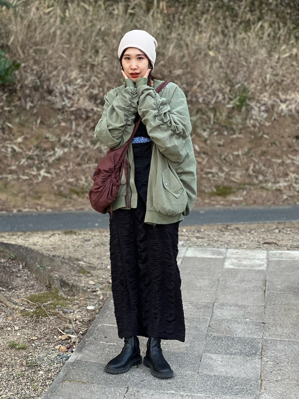 グリーン系のMA-1、ブラック系のキャミソール、ブラック系のスカートを着用したレディースの春コーディネートの5枚目の写真