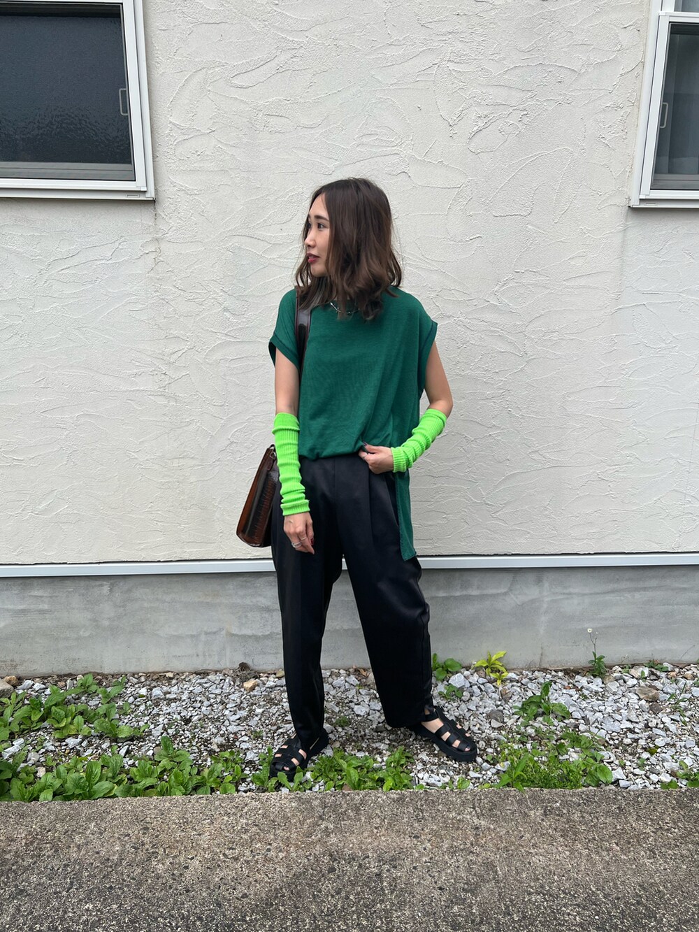 グリーン系のTシャツ/カットソー、ブラック系のサンダル、ブラウン系のトートバッグを着用したレディースの夏コーディネートの2枚目の写真