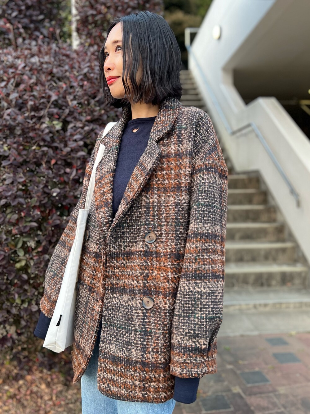 ブルー系のTシャツ/カットソー、ブラウン系のジャケット/アウター、ブルー系のデニムパンツを着用したレディースの冬コーディネートの2枚目の写真