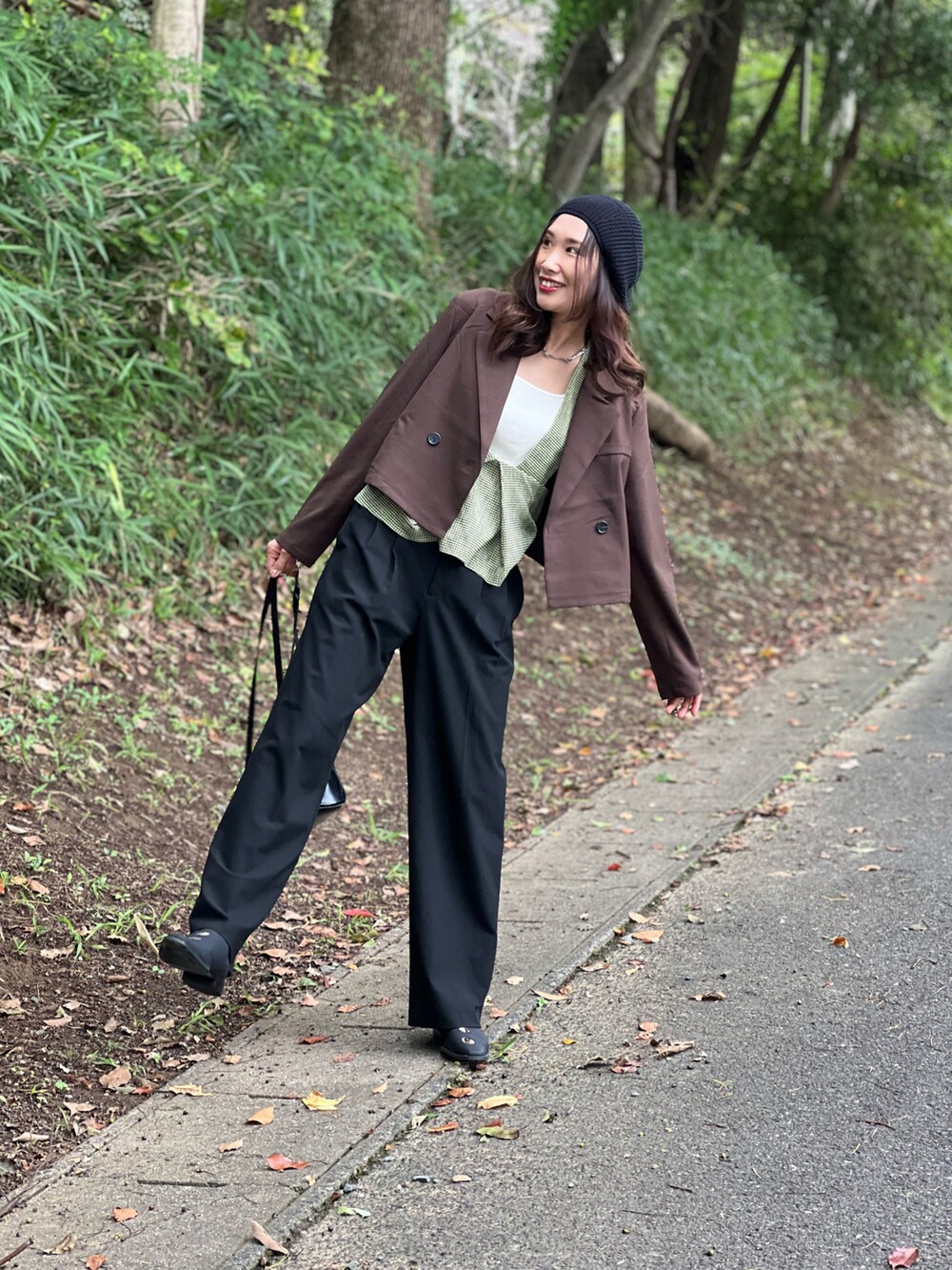 グリーン系のベスト、ブラウン系のジャケット/アウター、ブラック系のパンツを着用したレディースの秋コーディネートの4枚目の写真