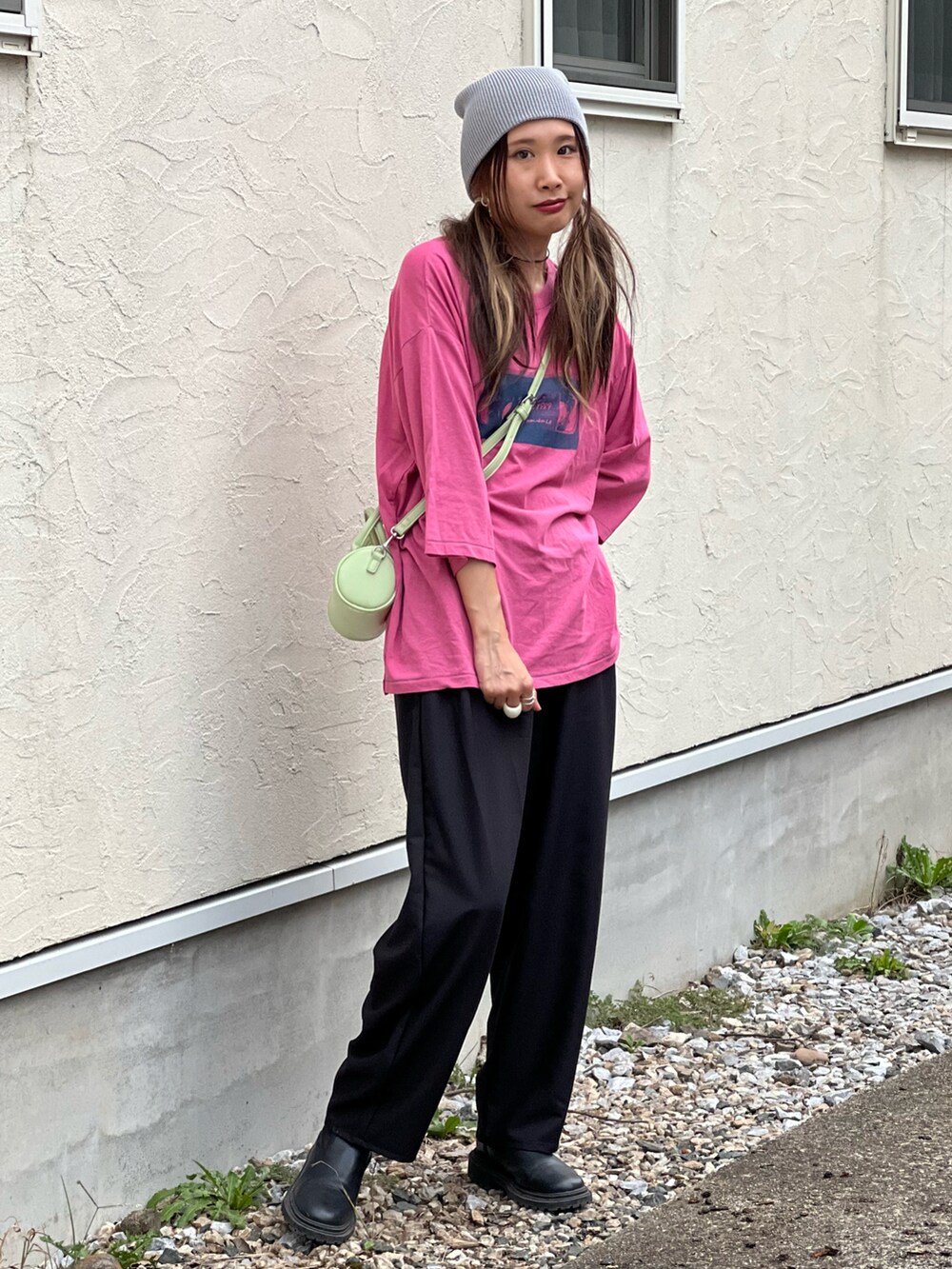 ピンク系のTシャツ/カットソー、ブラック系のスラックス、グリーン系のショルダーバッグを着用したレディースの秋コーディネートの3枚目の写真