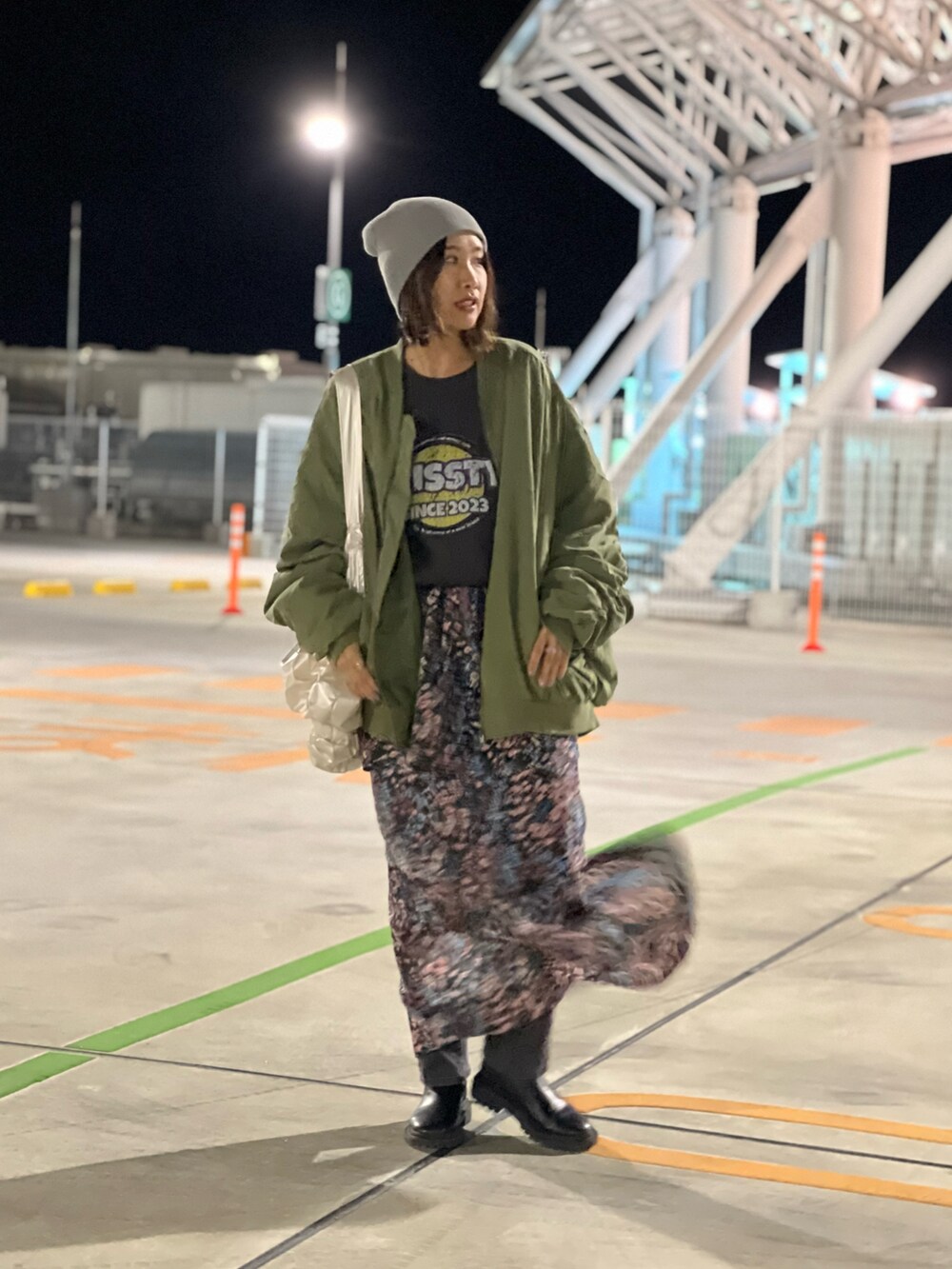 グレー系のスウェット、ブラック系のスカート、グレー系のデニムパンツを着用したレディースの秋コーディネートの4枚目の写真