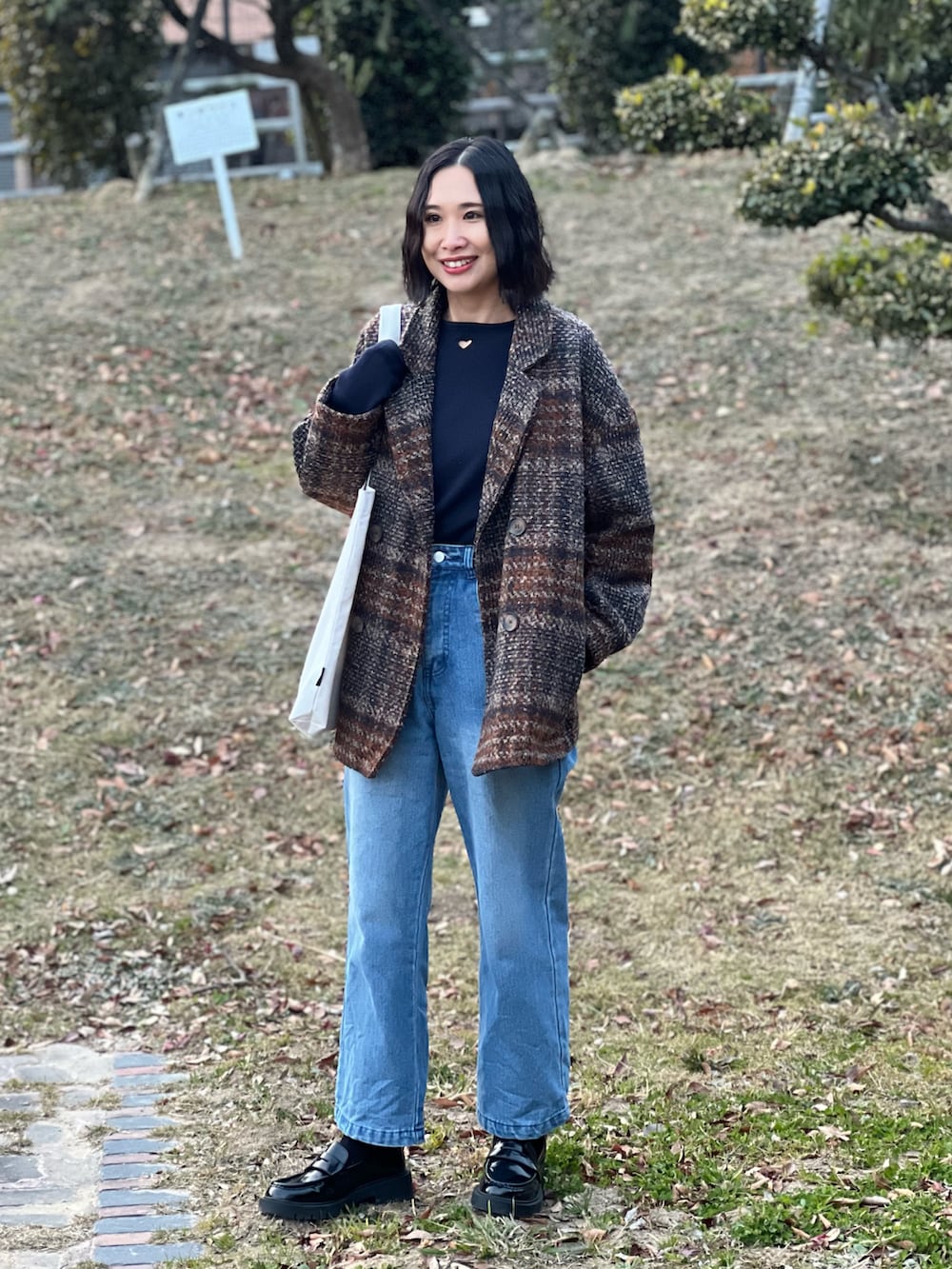 ブルー系のTシャツ/カットソー、ブラウン系のジャケット/アウター、ブルー系のデニムパンツを着用したレディースの冬コーディネートの4枚目の写真