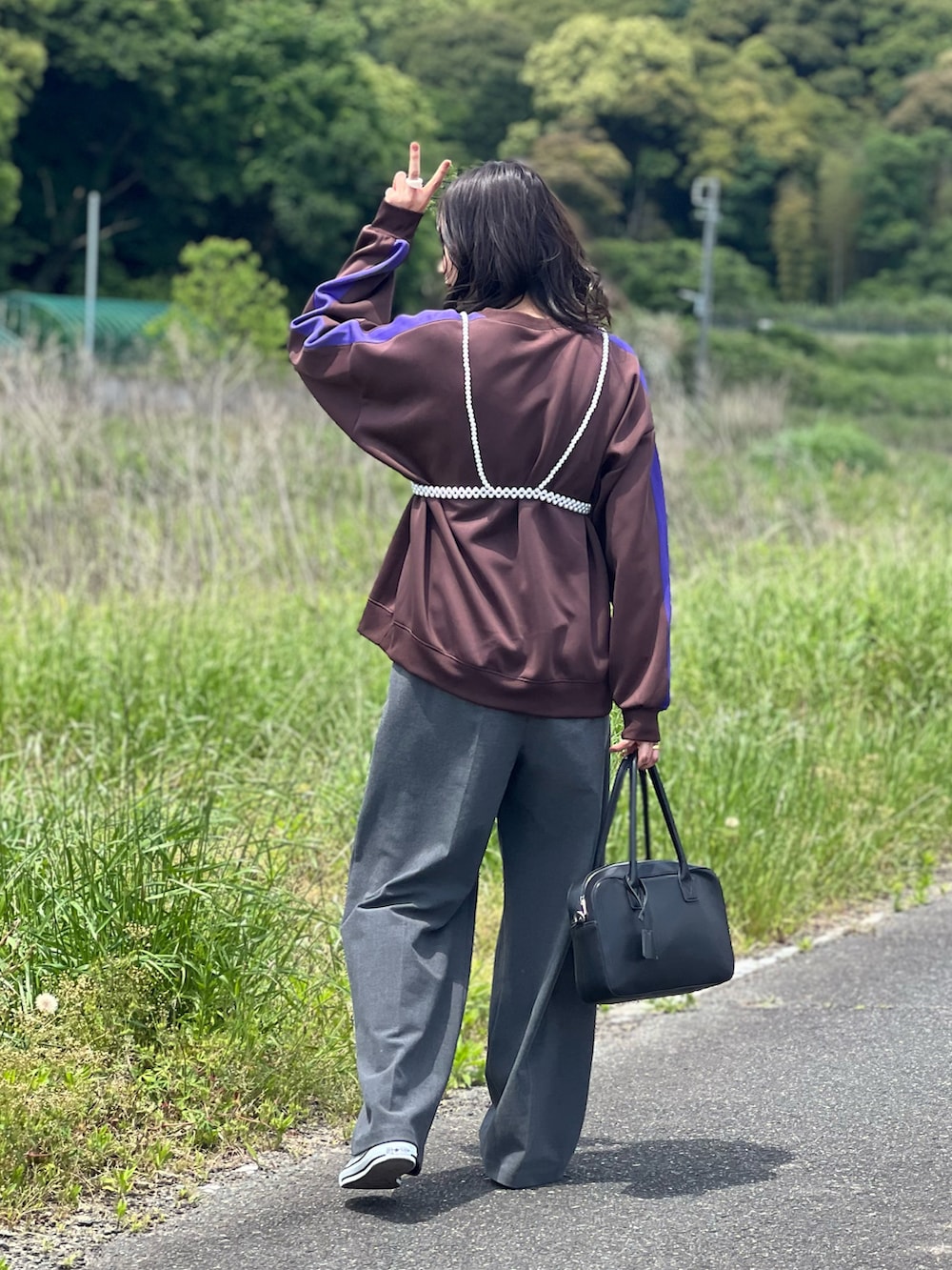 ブラウン系のその他トップス、グレー系のパンツ、シルバー系のスニーカーを着用したレディースの春コーディネートの2枚目の写真