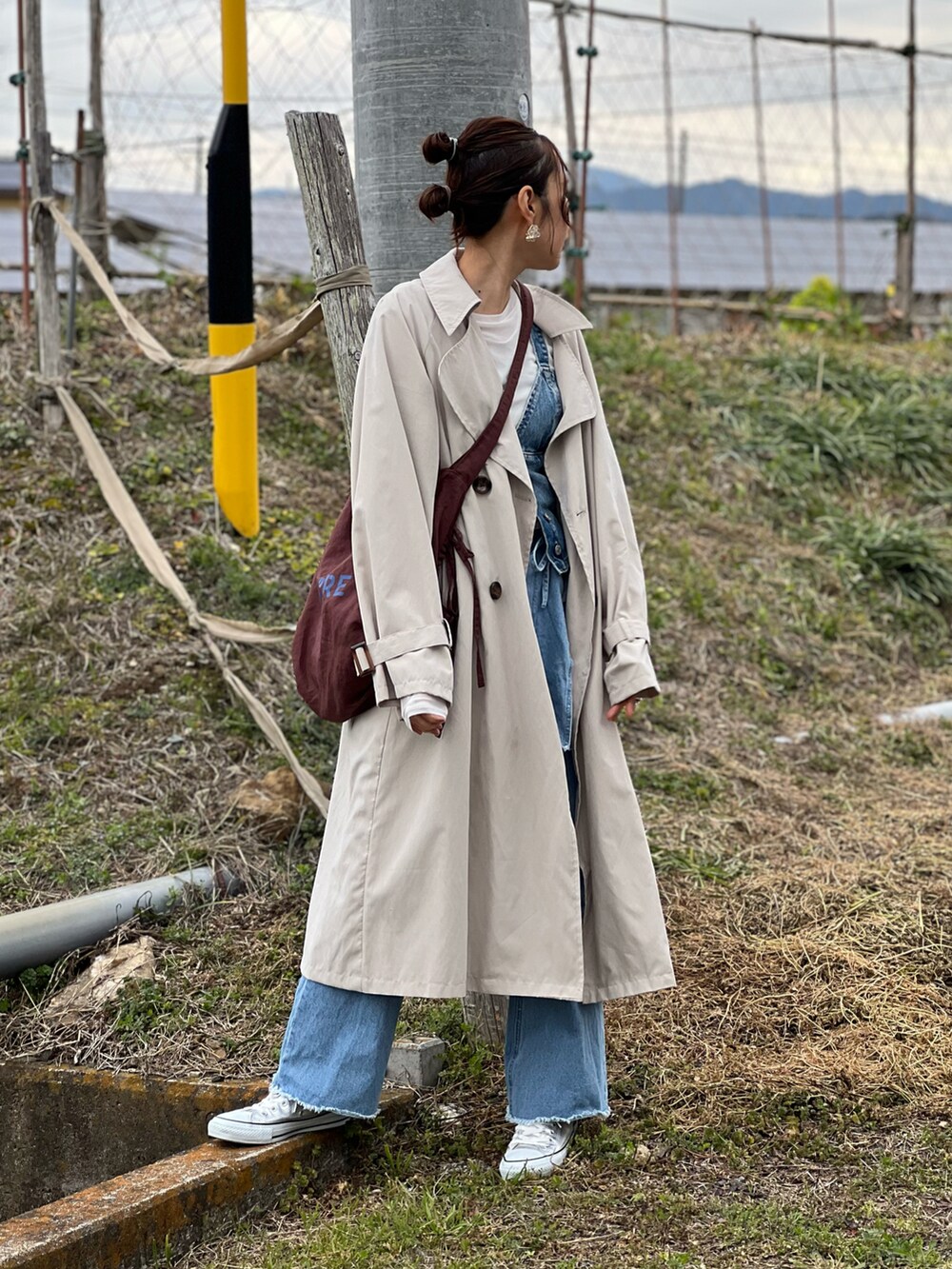 ベージュ系のトレンチコート、ホワイト系のTシャツ/カットソー、ブルー系のその他トップスを着用したレディースの春コーディネートの3枚目の写真