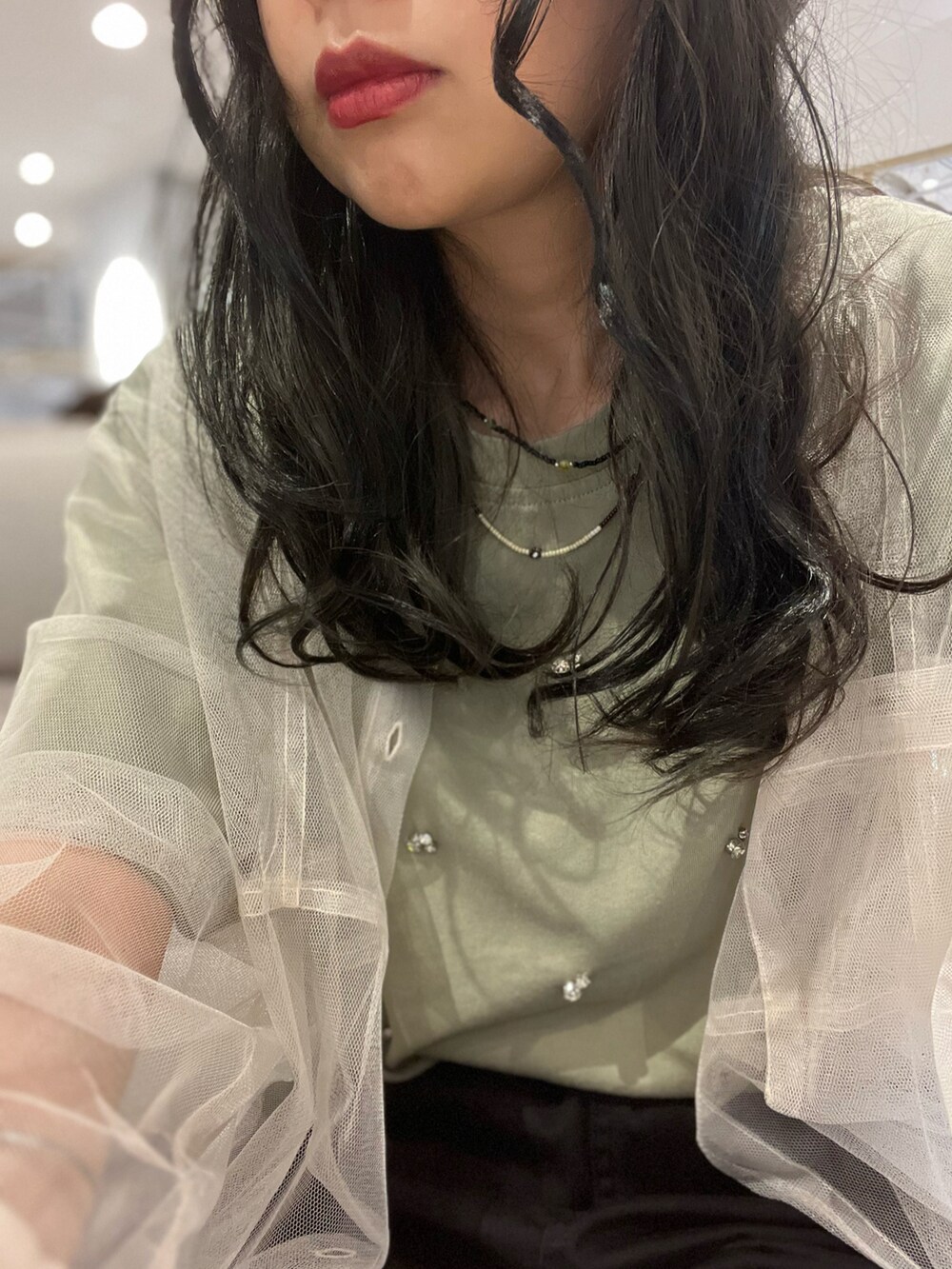 グリーン系のTシャツ/カットソー、ブラック系のパンツ、ホワイト系のシャツ/ブラウスを着用したレディースの夏コーディネートの5枚目の写真