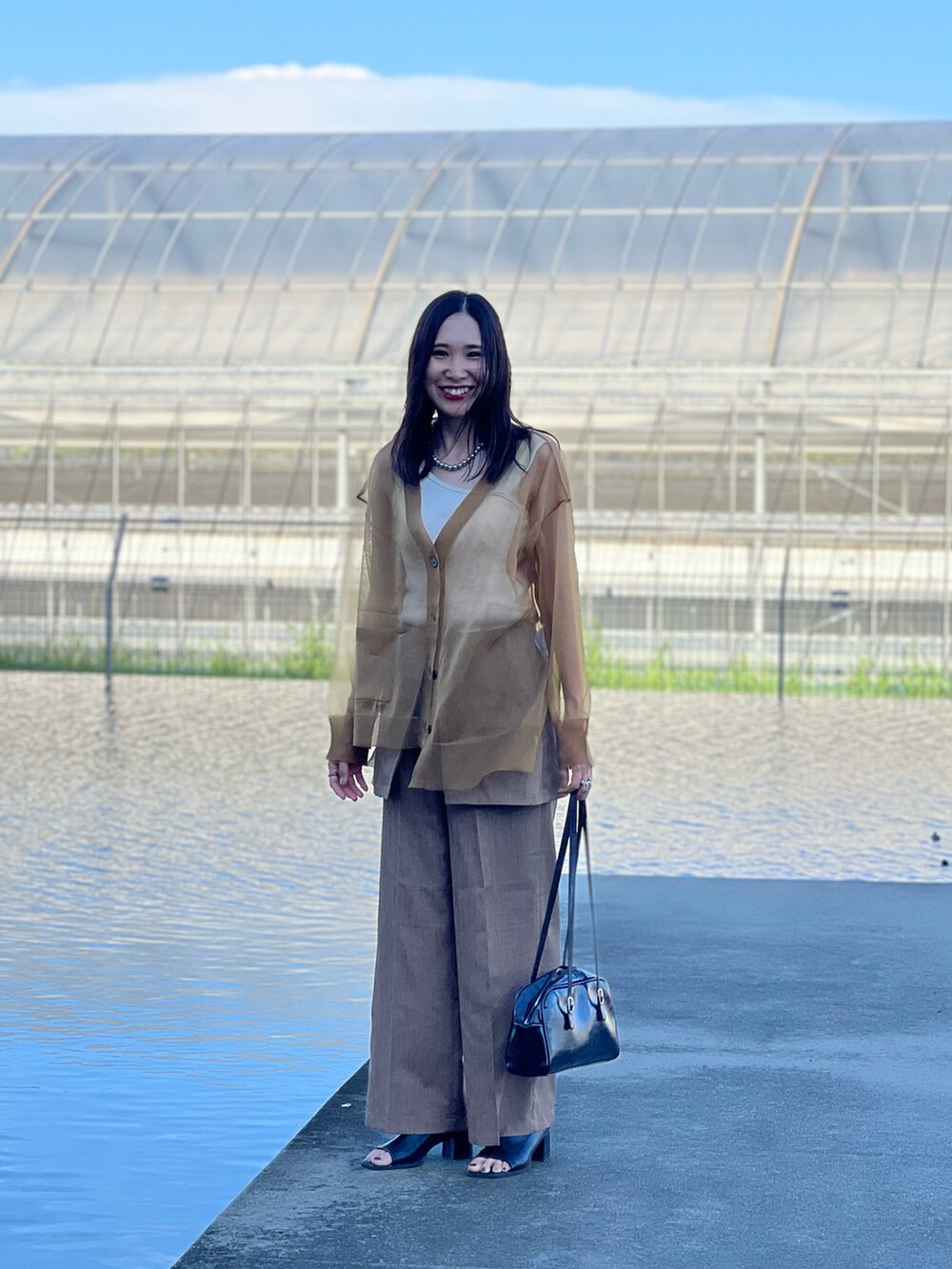 イエロー系のカーディガン/ボレロ、ベージュ系のその他パンツ、ブラック系のブーツを着用したレディースの夏コーディネートの3枚目の写真