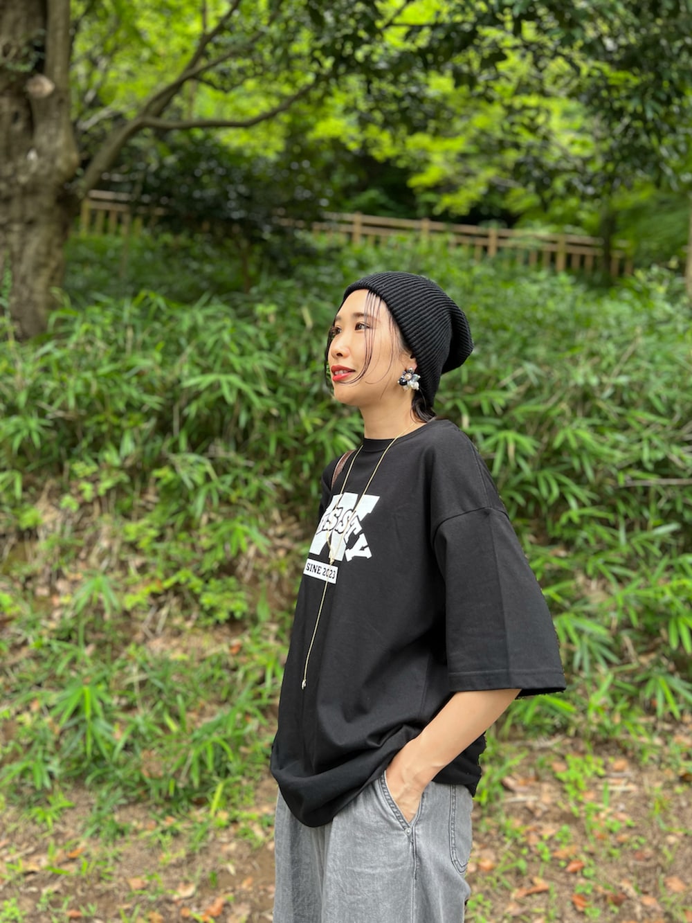 ブラック系のTシャツ/カットソー、グレー系のデニムパンツ、ブラウン系のショルダーバッグを着用したレディースの夏コーディネートの2枚目の写真