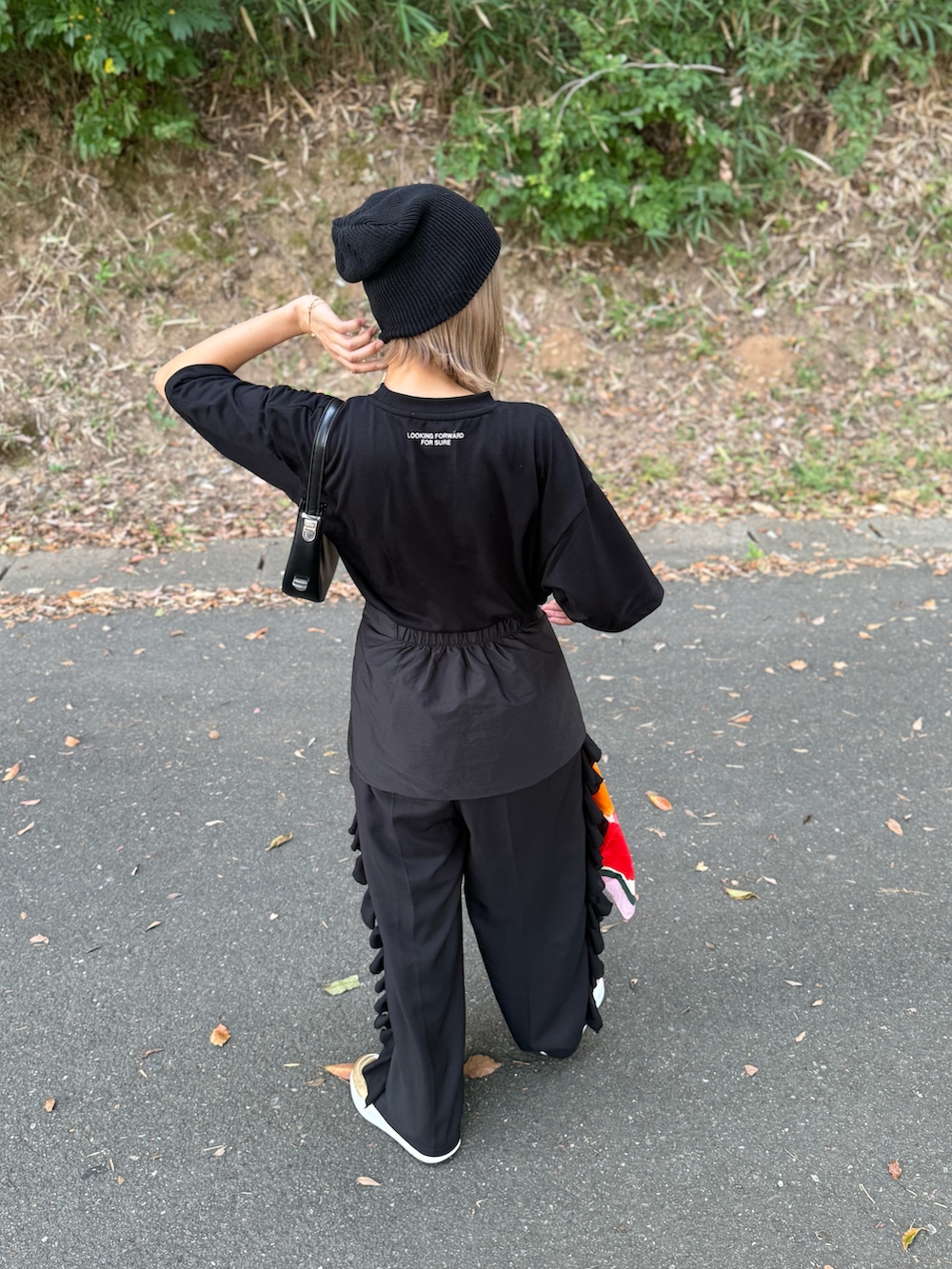 ブラック系のTシャツ/カットソー、ブラック系のその他パンツ、ゴールド系のスニーカーを着用したレディースの夏コーディネートの3枚目の写真