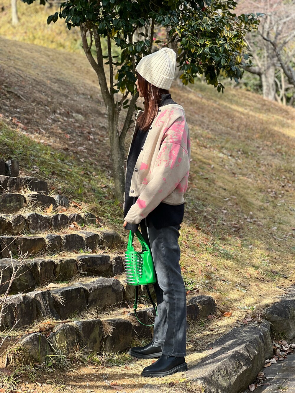 ベージュ系のカーディガン/ボレロ、グリーン系のトートバッグ、ブラック系のニット/セーターを着用したレディースの冬コーディネートの5枚目の写真