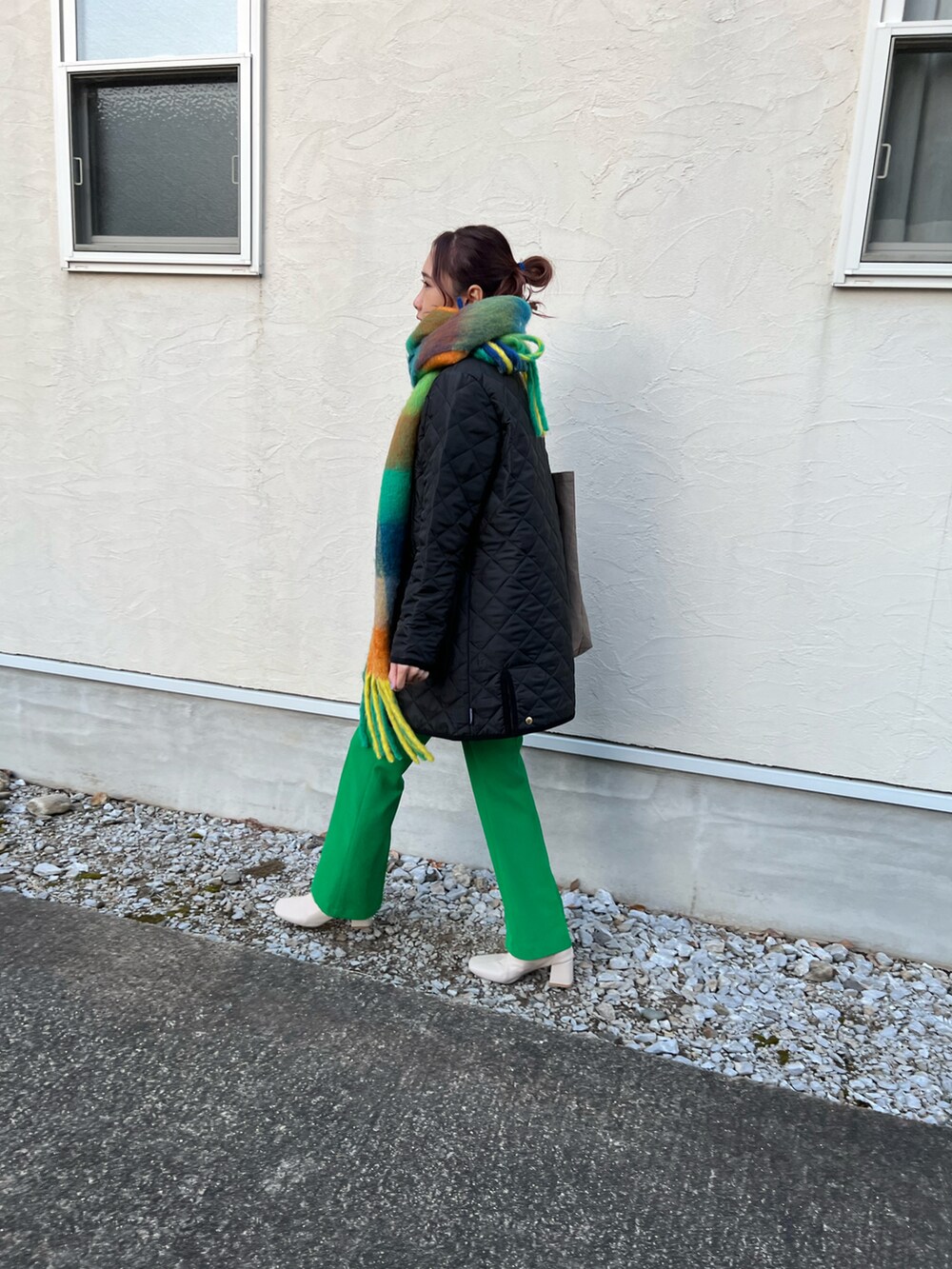 ブラック系のその他アウター、ブラウン系のトートバッグ、グリーン系のスラックスを着用したレディースの冬コーディネートの4枚目の写真