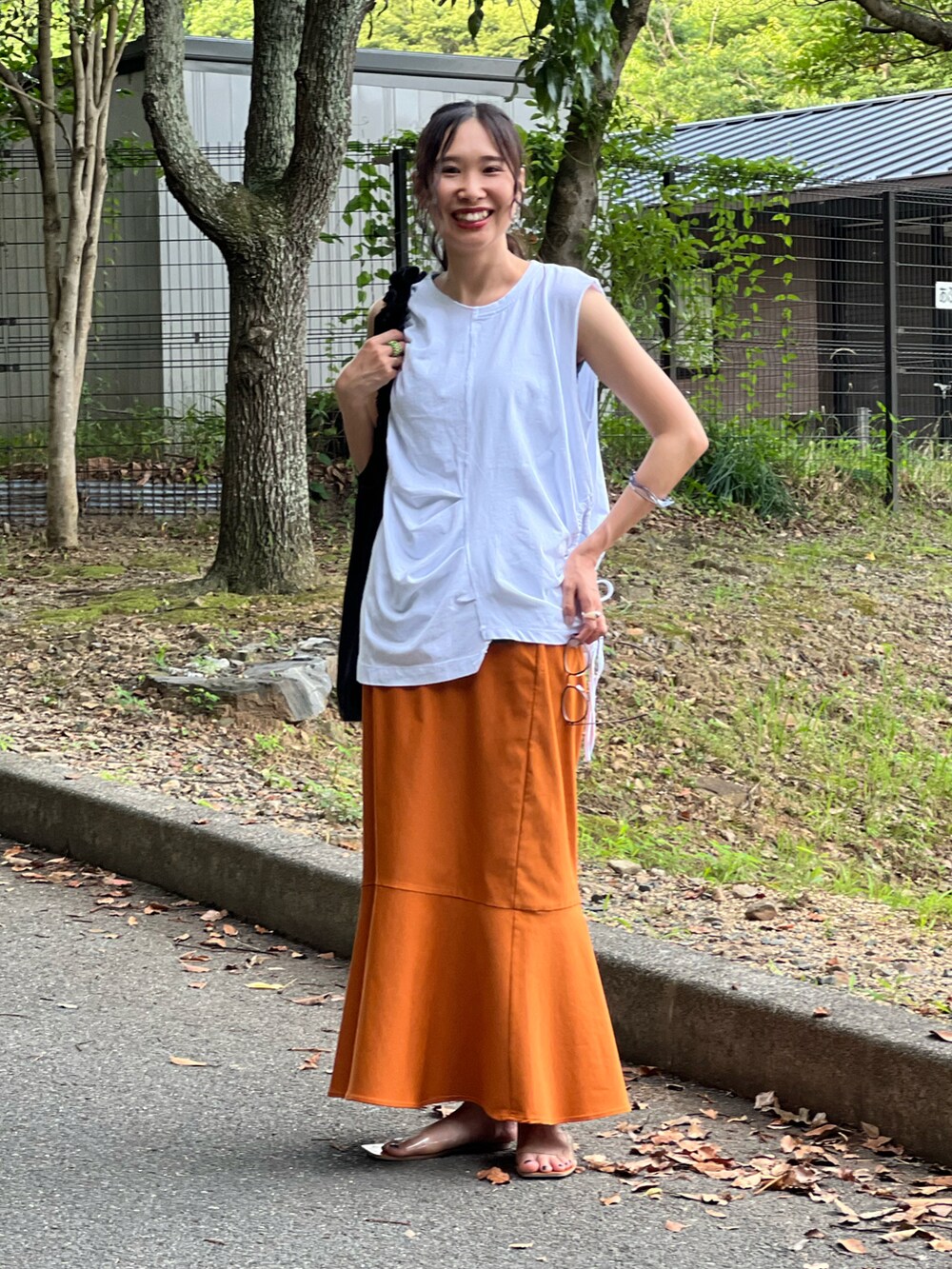 ホワイト系のTシャツ/カットソー、グリーン系のタンクトップ、イエロー系のスカートを着用したレディースの夏コーディネートの4枚目の写真