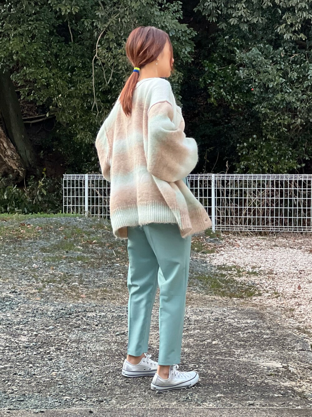 グリーン系のその他パンツ、レッド系のTシャツ/カットソー、グリーン系のカーディガン/ボレロを着用したレディースの冬コーディネートの2枚目の写真