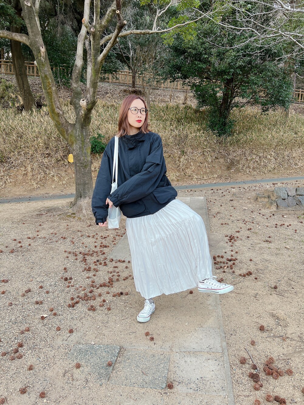 ブラック系のブルゾン、グレー系のスカート、ホワイト系のスニーカーを着用したレディースの春コーディネートの4枚目の写真