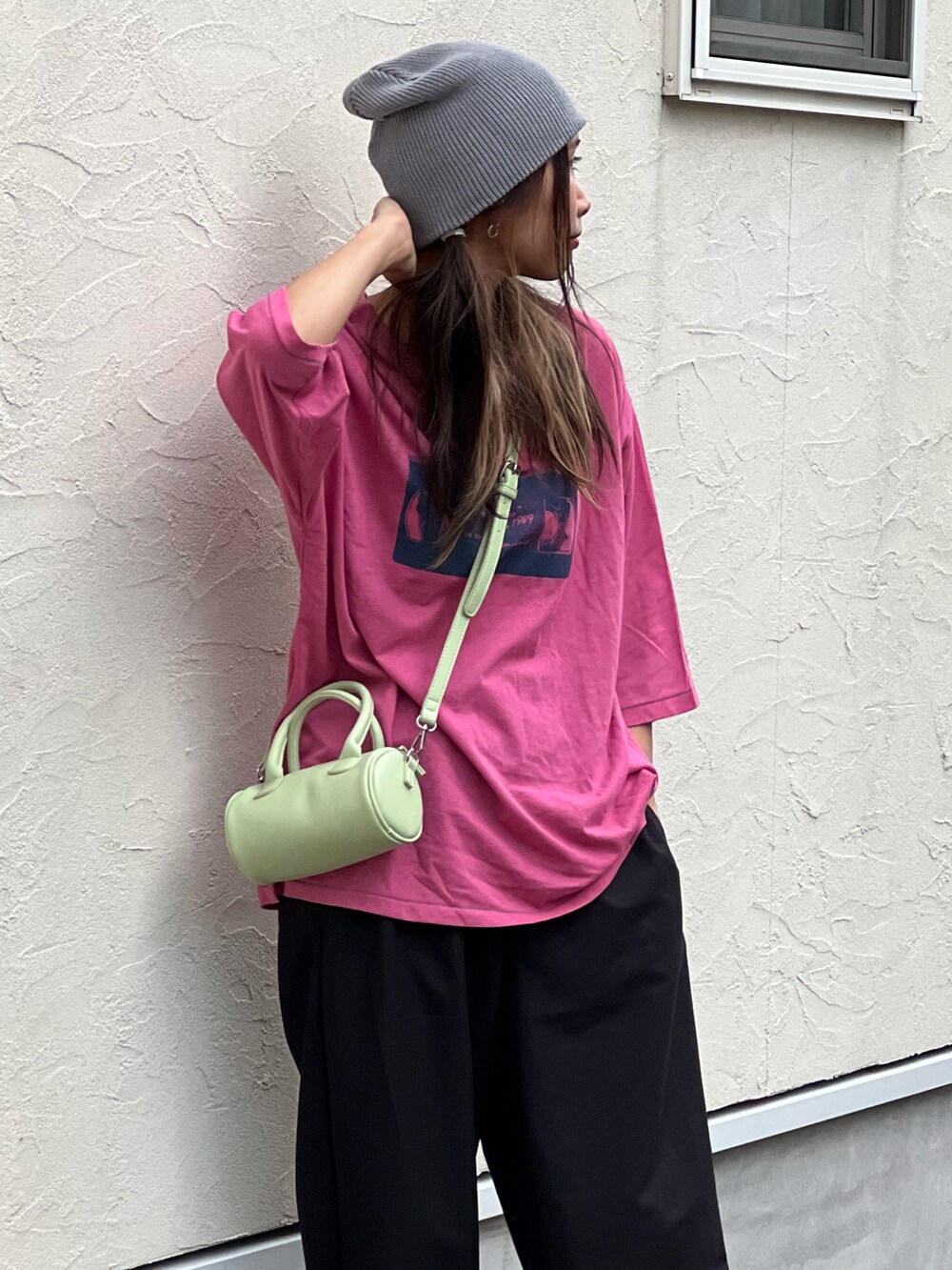ピンク系のTシャツ/カットソー、ブラック系のスラックス、グリーン系のショルダーバッグを着用したレディースの秋コーディネートの4枚目の写真