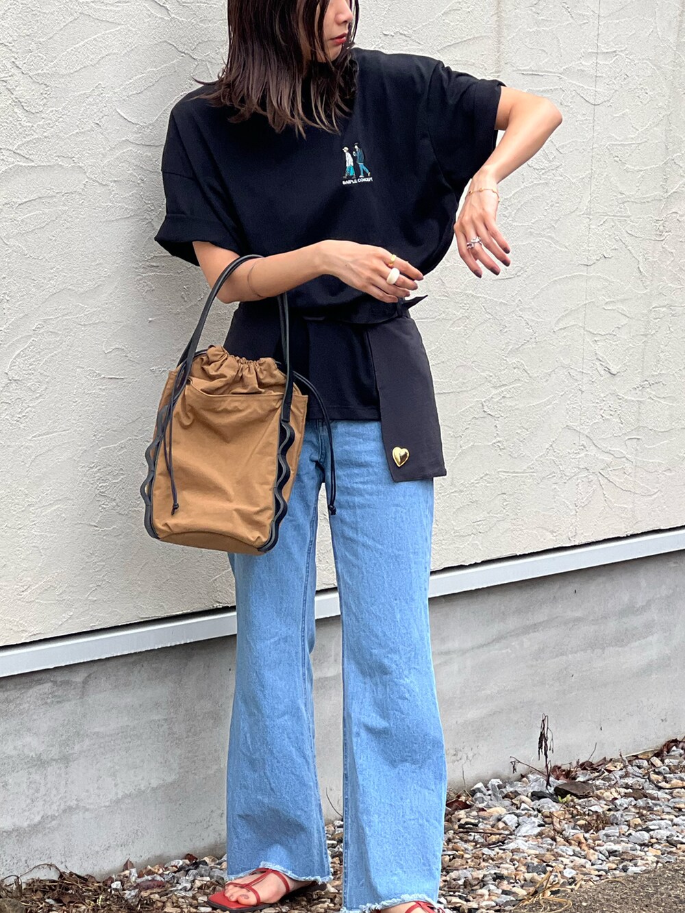 ブラック系のTシャツ/カットソー、ブルー系のデニムパンツ、ベージュ系のトートバッグを着用したレディースの春コーディネートの3枚目の写真