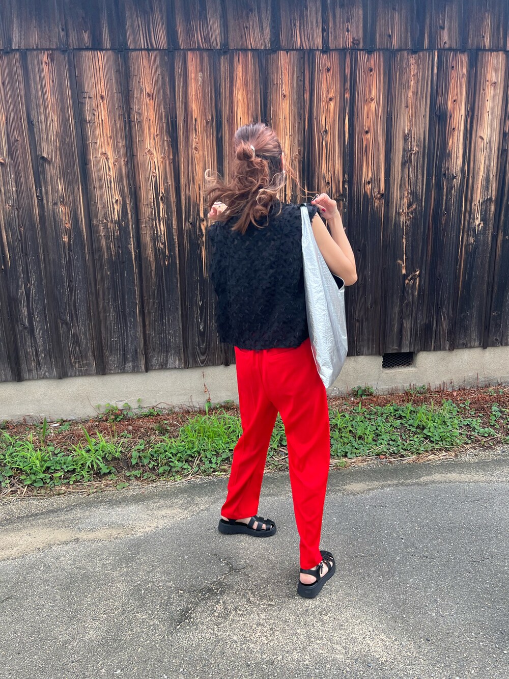 ブラック系のシャツ/ブラウス、レッド系のスラックス、ブラック系のサンダルを着用したレディースの夏コーディネートの2枚目の写真