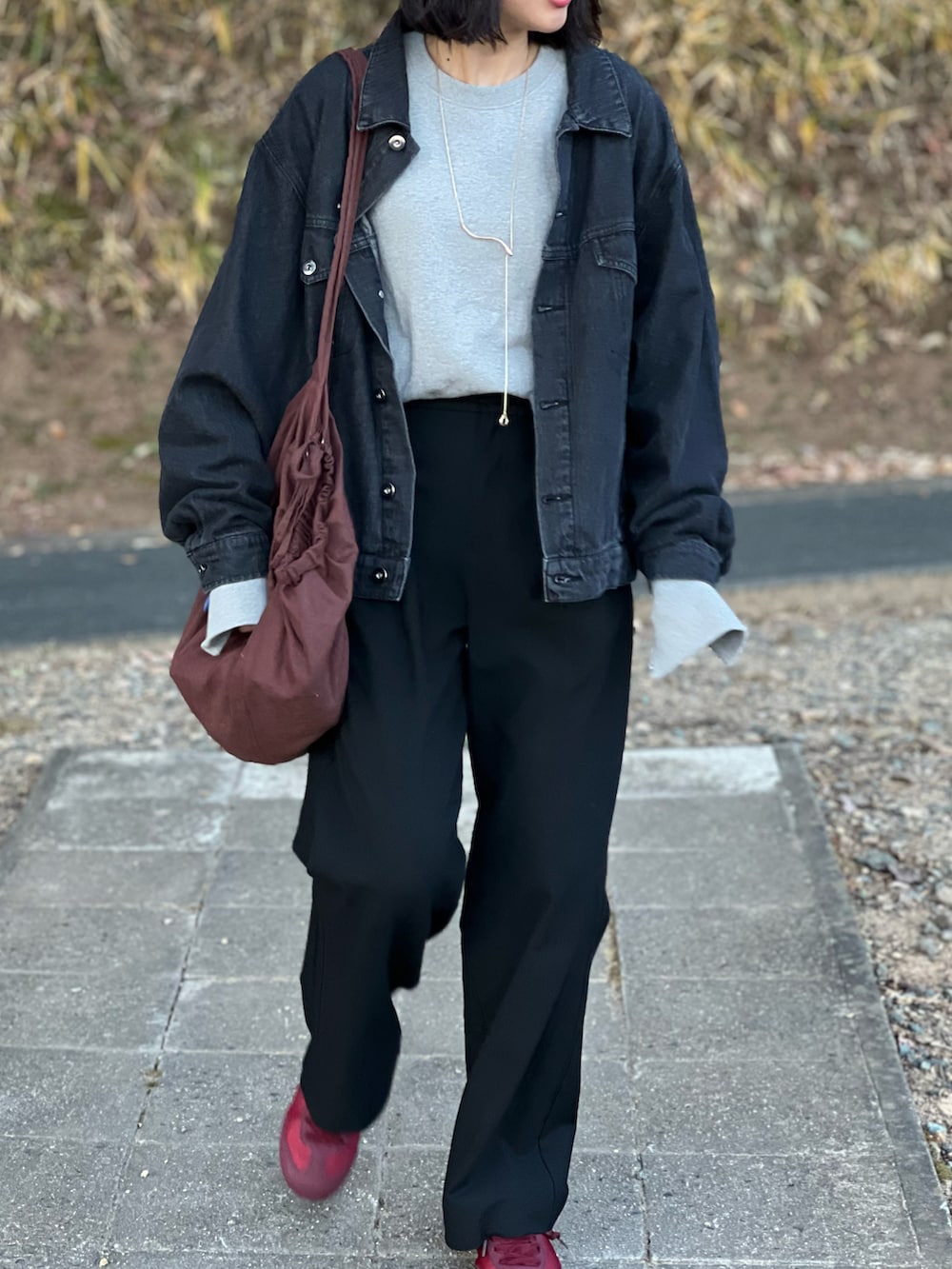 ブラック系のデニムジャケット、グレー系のスウェット、ブラック系のパンツを着用したレディースの冬コーディネートの2枚目の写真