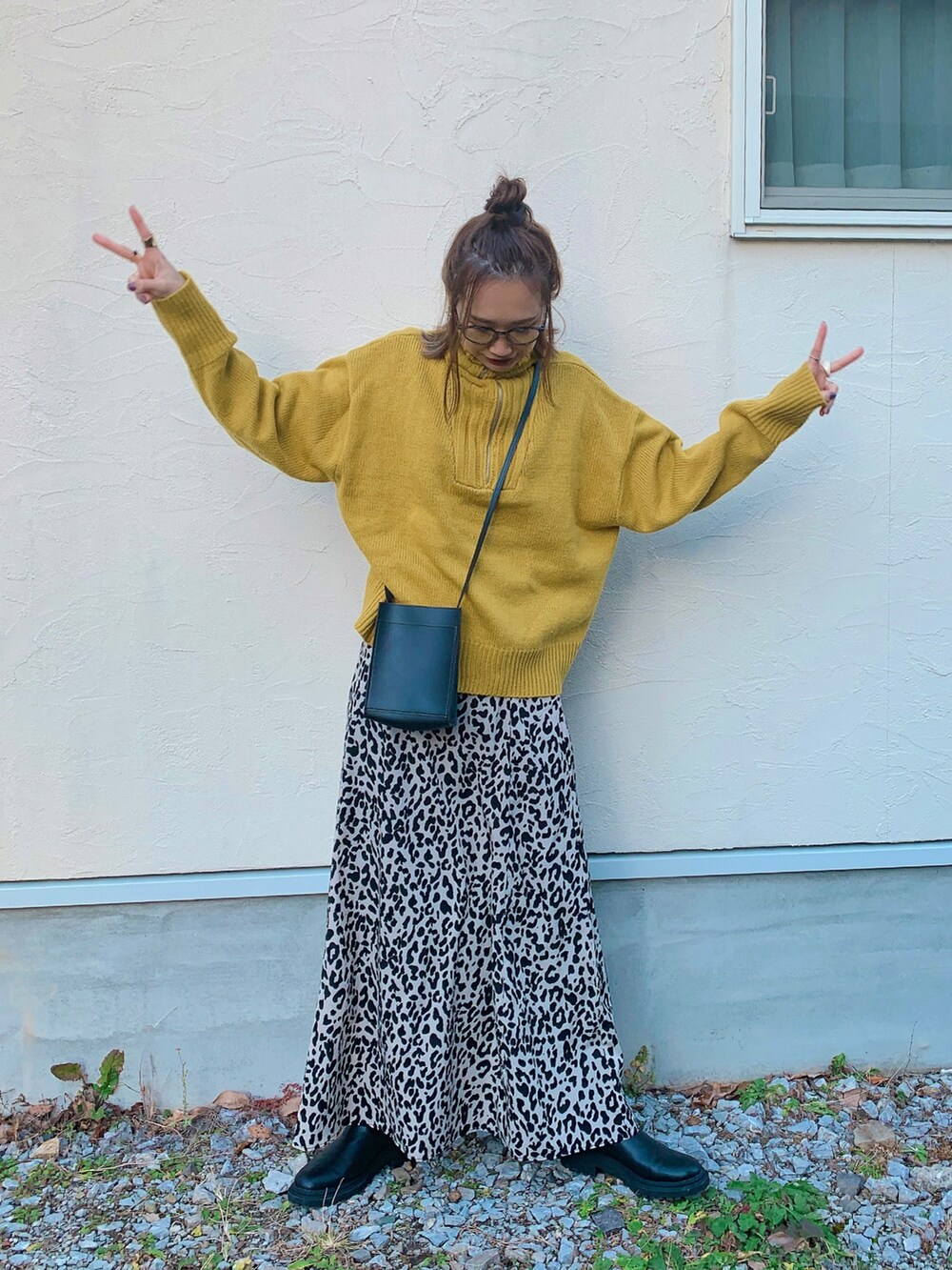 イエロー系のニット/セーター、ベージュ系のスカート、ブラック系のトートバッグを着用したレディースの冬コーディネートの3枚目の写真