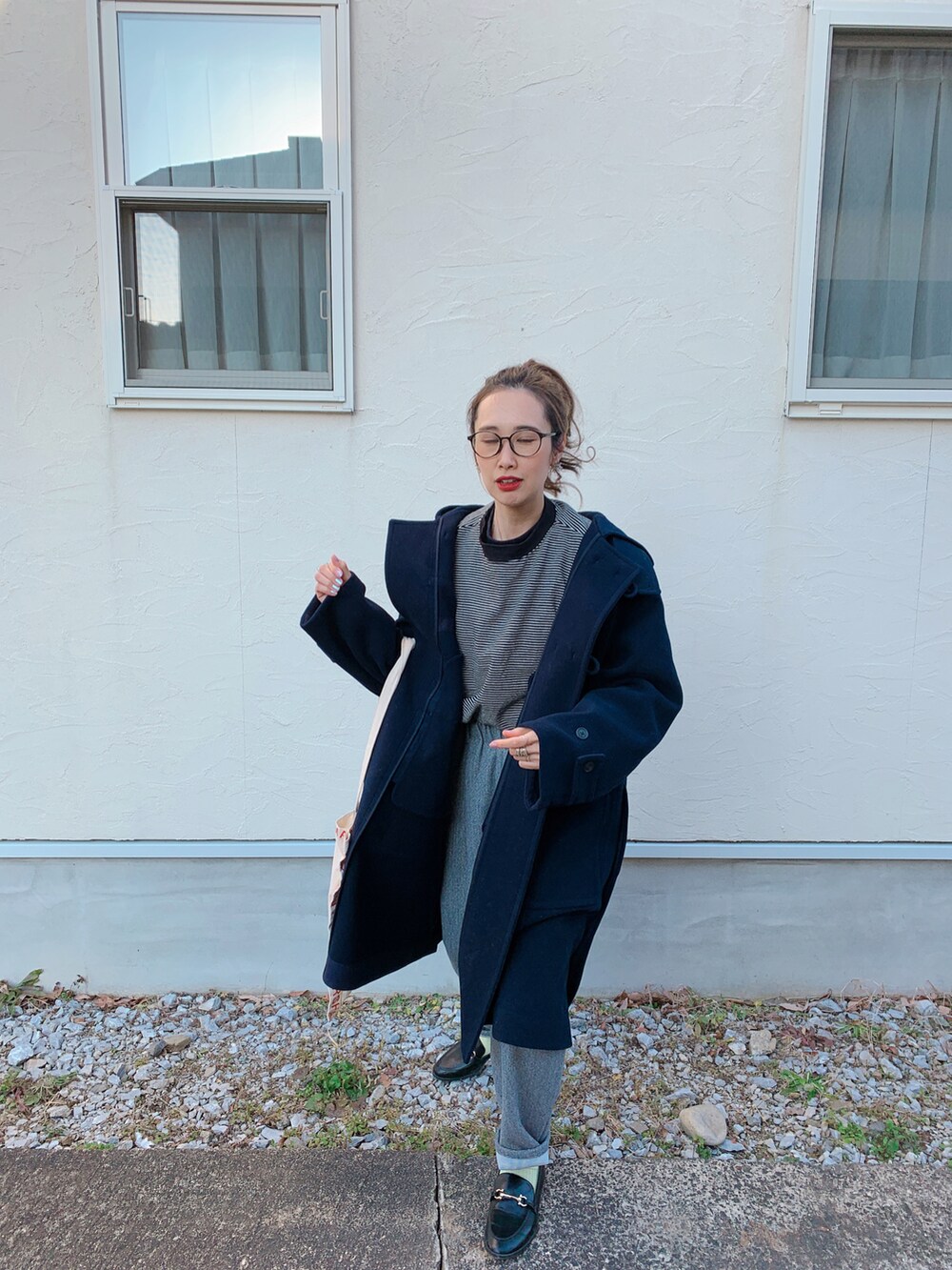 ブラック系のダッフルコート、ブラック系のローファー、レッド系のトートバッグを着用したレディースの冬コーディネートの4枚目の写真