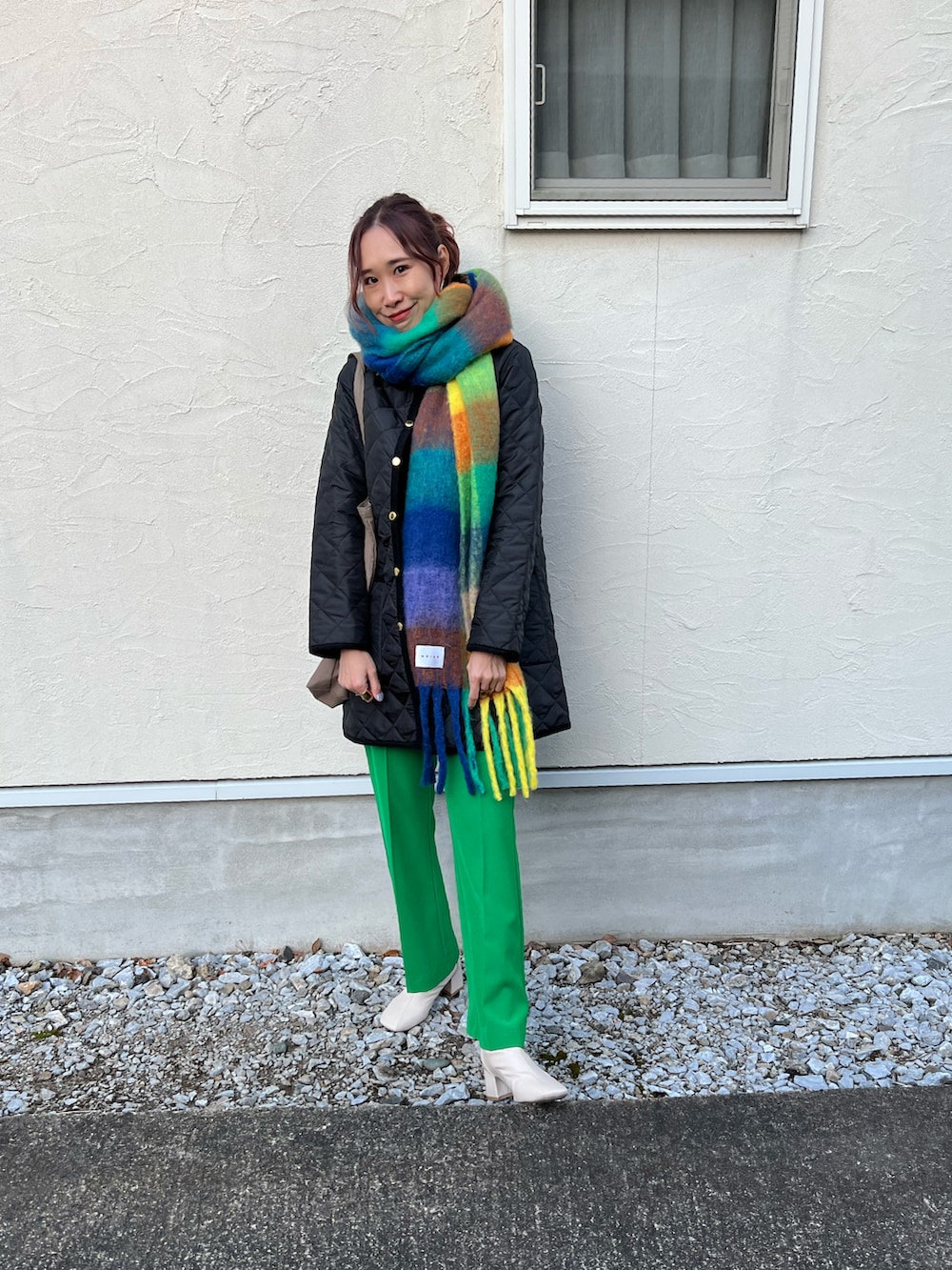 ブラック系のその他アウター、ブラウン系のトートバッグ、グリーン系のスラックスを着用したレディースの冬コーディネートの5枚目の写真