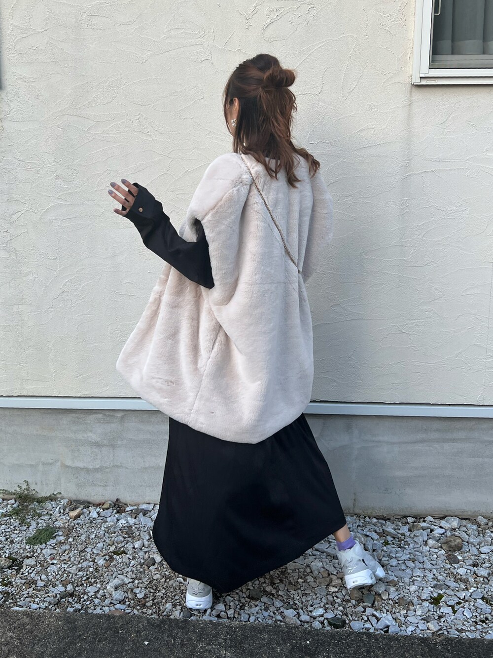 ブラック系のワンピース、ホワイト系のベスト、グレー系のスニーカーを着用したレディースの秋コーディネートの5枚目の写真