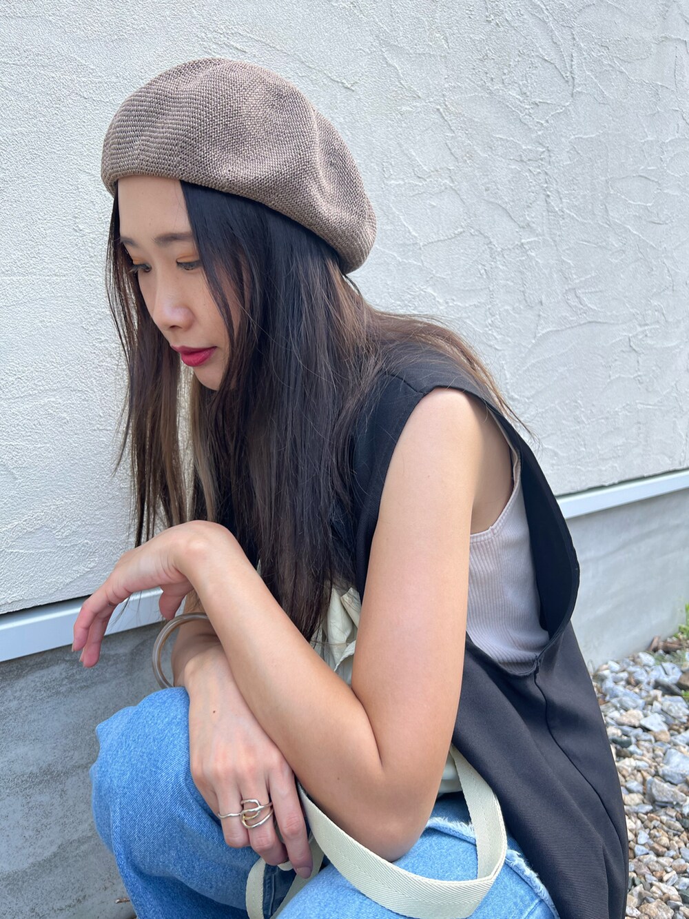 ブルー系のデニムパンツ、ベージュ系のショルダーバッグ、ブラック系のサンダルを着用したレディースの夏コーディネートの2枚目の写真