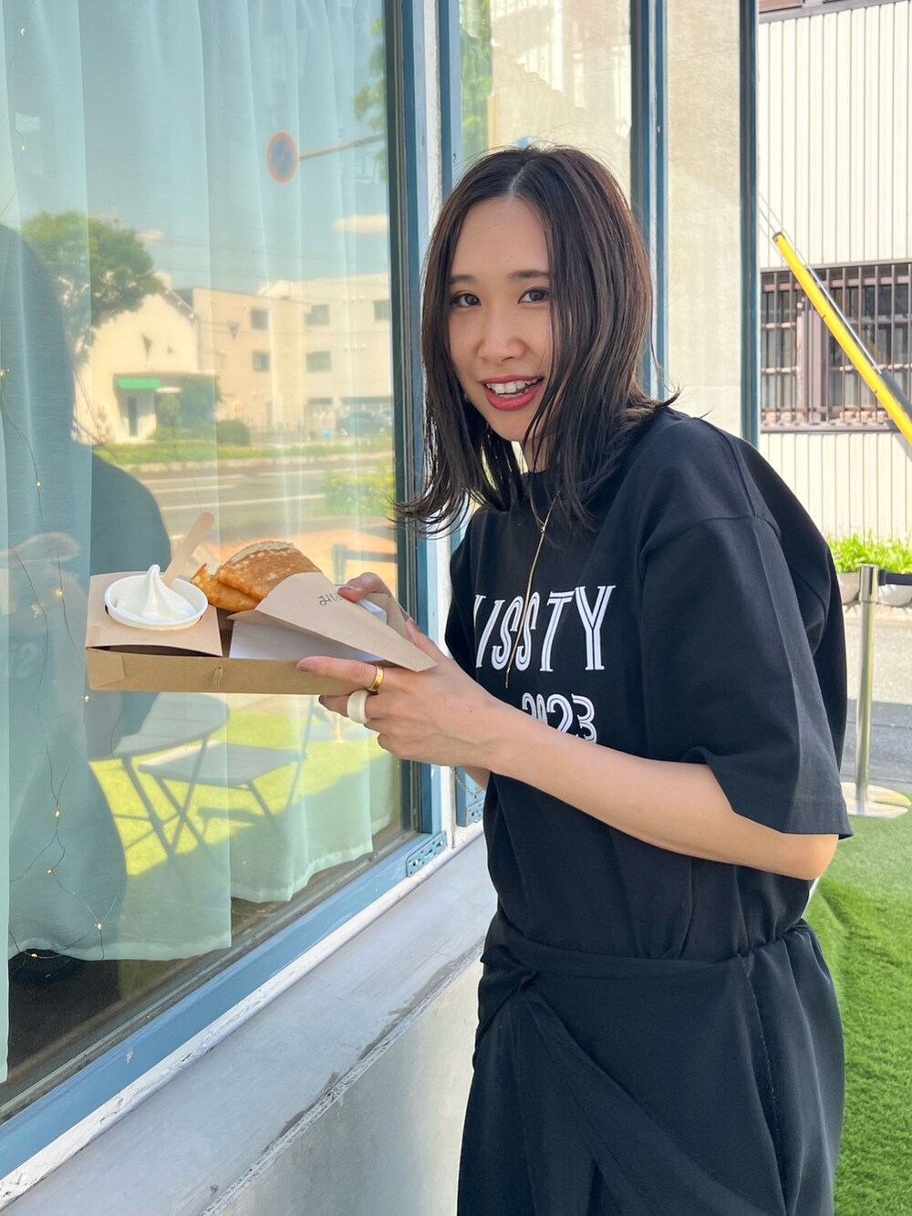 ブラック系のTシャツ/カットソー、ブラック系のブーツ、グリーン系のボストンバッグを着用したレディースの春コーディネートの3枚目の写真