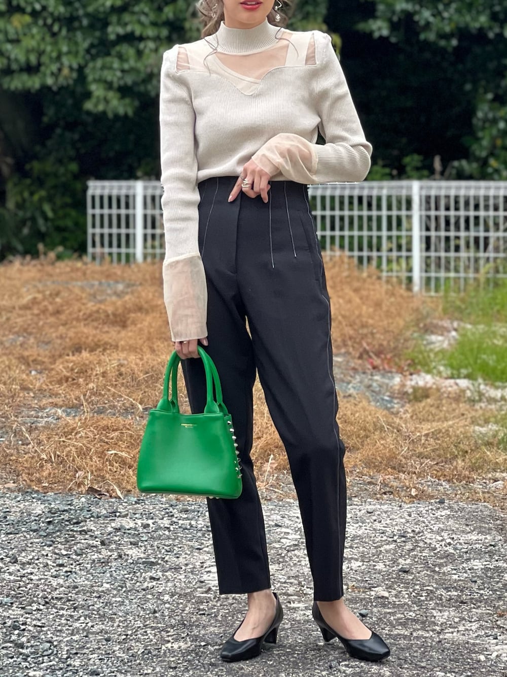 ブラック系のパンプス、ベージュ系のニット/セーター、ベージュ系のタンクトップを着用したレディースの春コーディネートの3枚目の写真