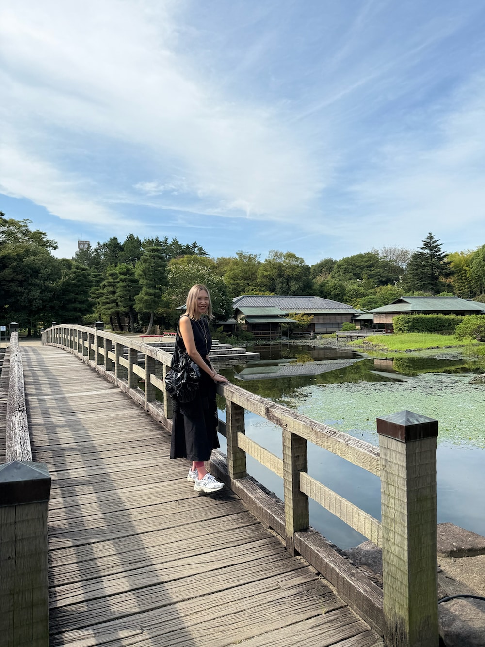 ブラック系のトートバッグ、シルバー系のスニーカー、ブラック系のワンピースを着用したレディースの秋コーディネートの4枚目の写真