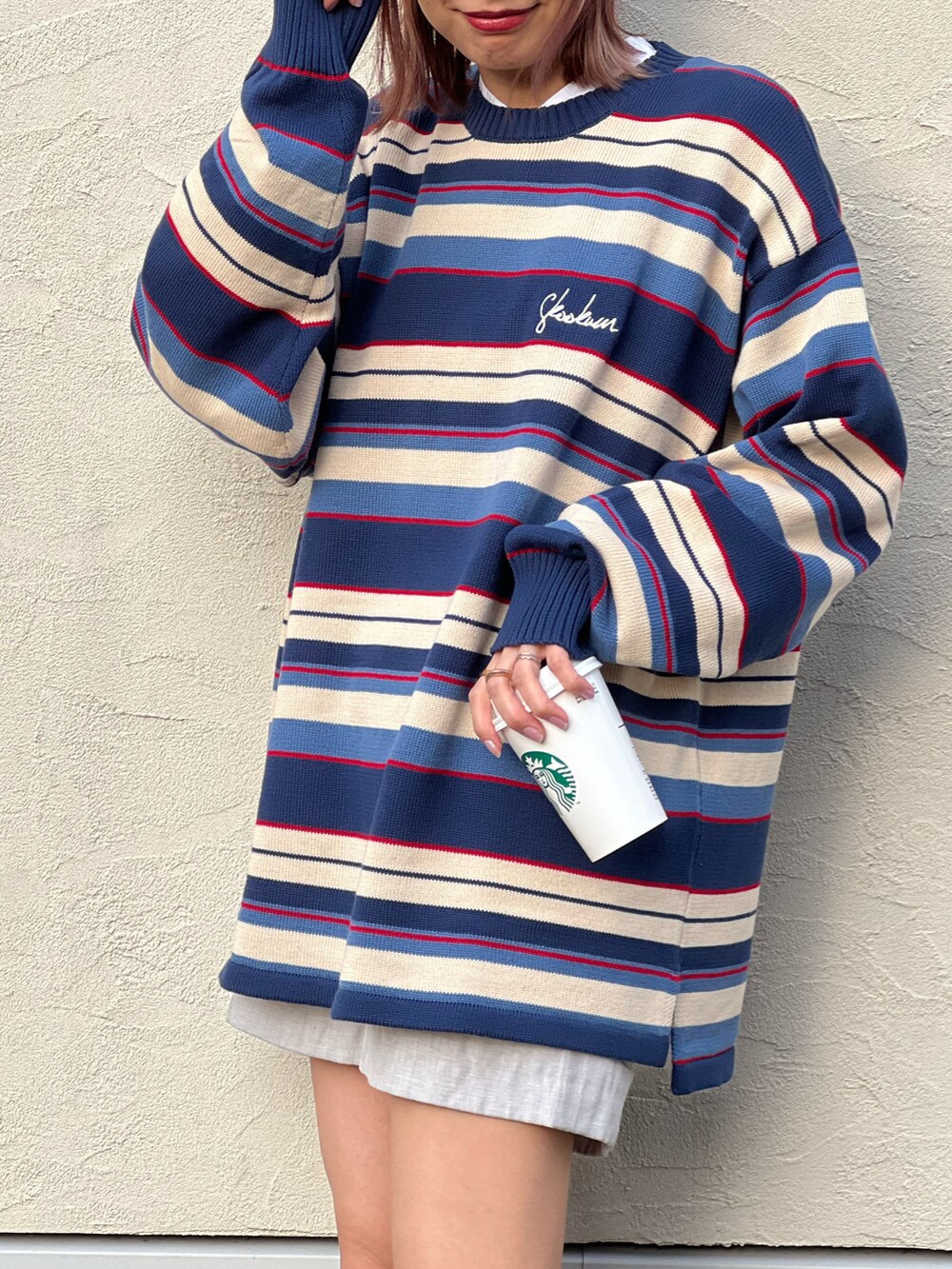 ブルー系のニット/セーター、ゴールド系のスニーカー、シルバー系のリングを着用したレディースの冬コーディネートの4枚目の写真