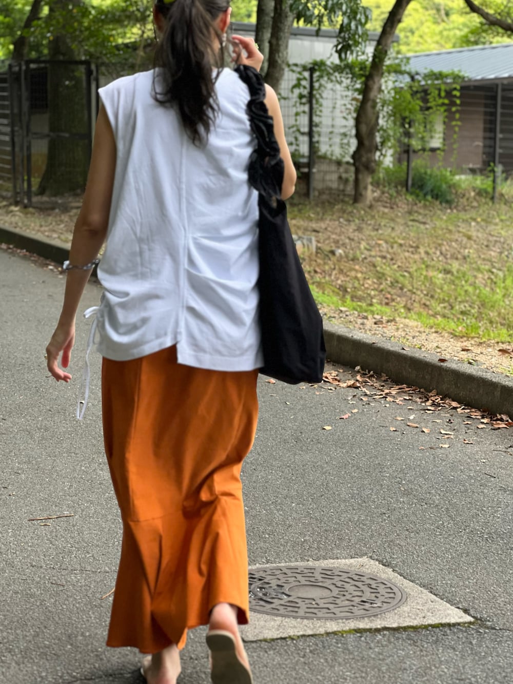 ホワイト系のTシャツ/カットソー、グリーン系のタンクトップ、イエロー系のスカートを着用したレディースの夏コーディネートの2枚目の写真