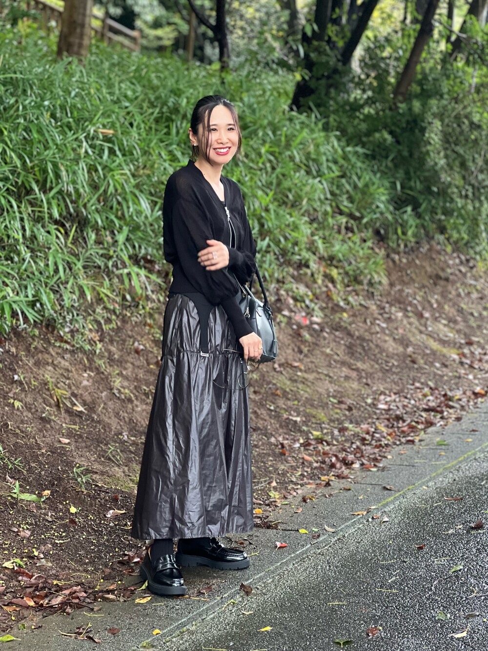 ブラック系のタンクトップ、ブラック系のカーディガン/ボレロ、ブラック系のスカートを着用したレディースの秋コーディネートの4枚目の写真